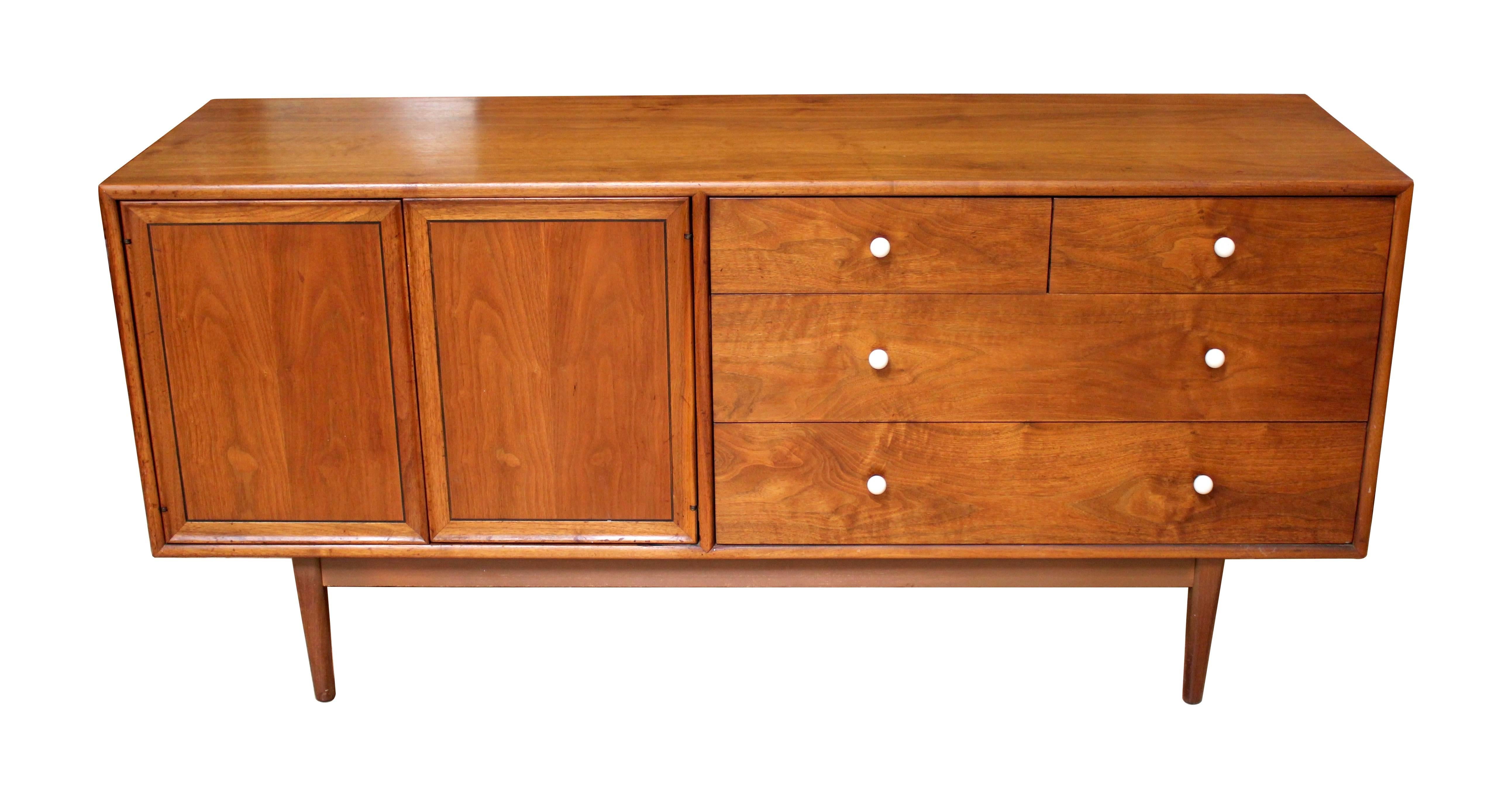 1960s walnut dresser designed by Kipp Stewart and Stewart McDougall for Drexel Declaration. The dresser features drawers on the right side, with a pair of cabinet doors on the left concealing additional drawers. Beautiful walnut wood grain and the