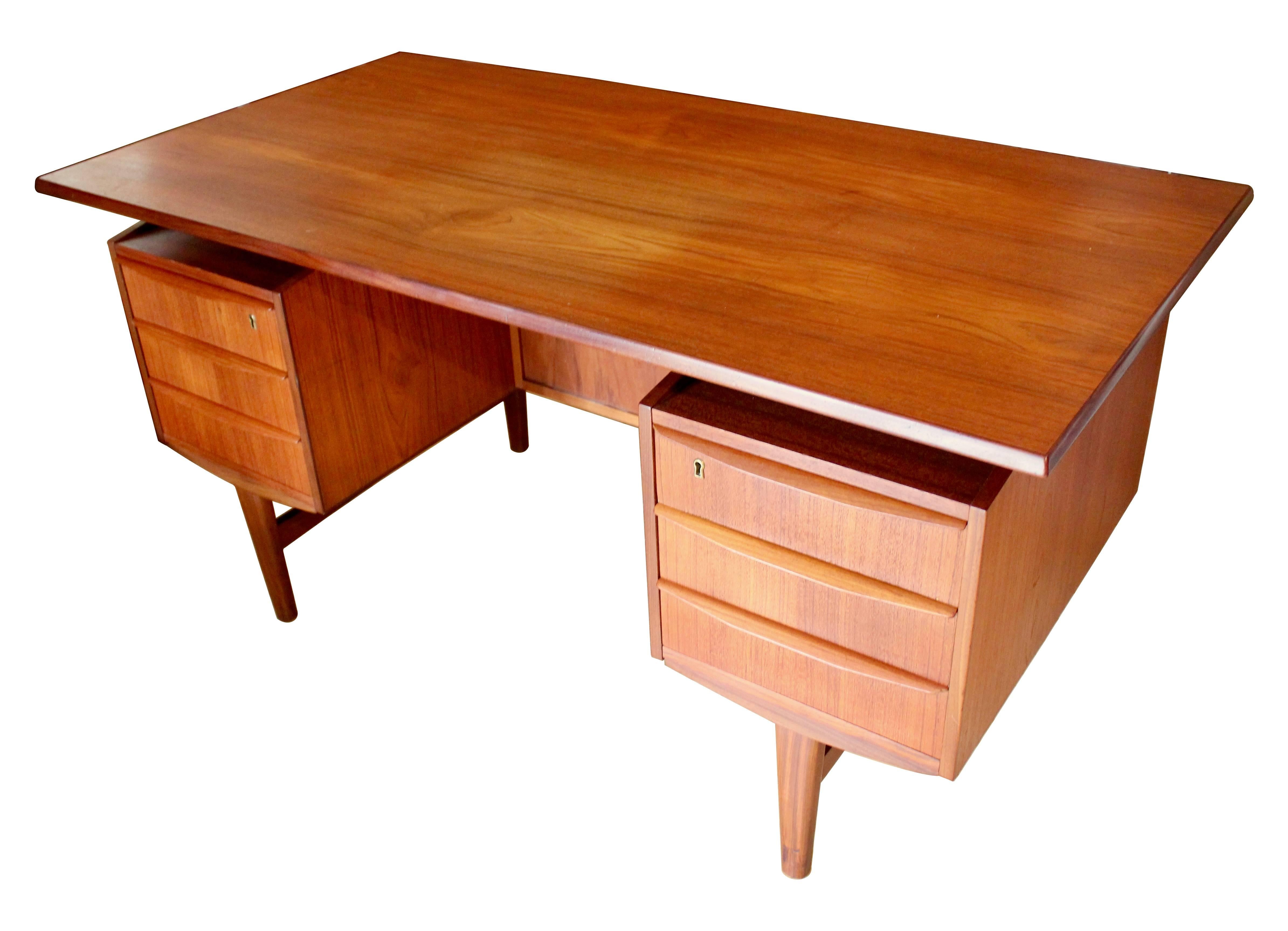 1960s Danish modern teak executive desk with floating top and locking executive bar. The desk features six drawers (two locking), two open shelves, and a drop-down bar with lock.