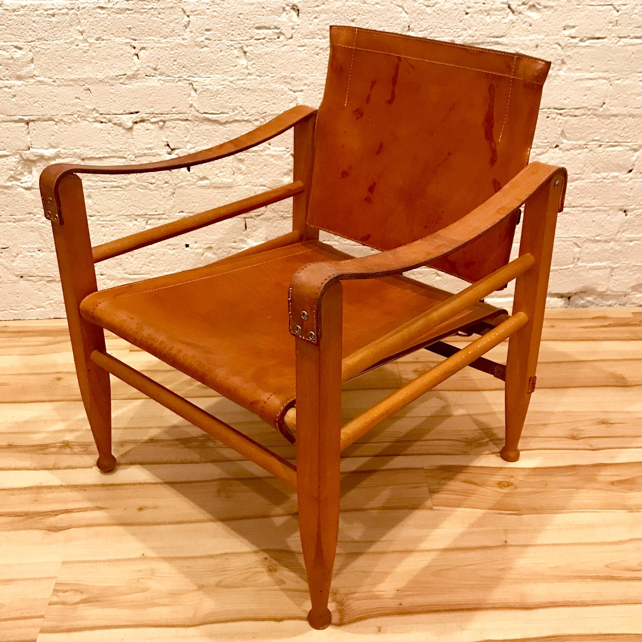Pair of Danish modern wood and leather safari chairs in the style of Kaare Klint. Price is for the pair.