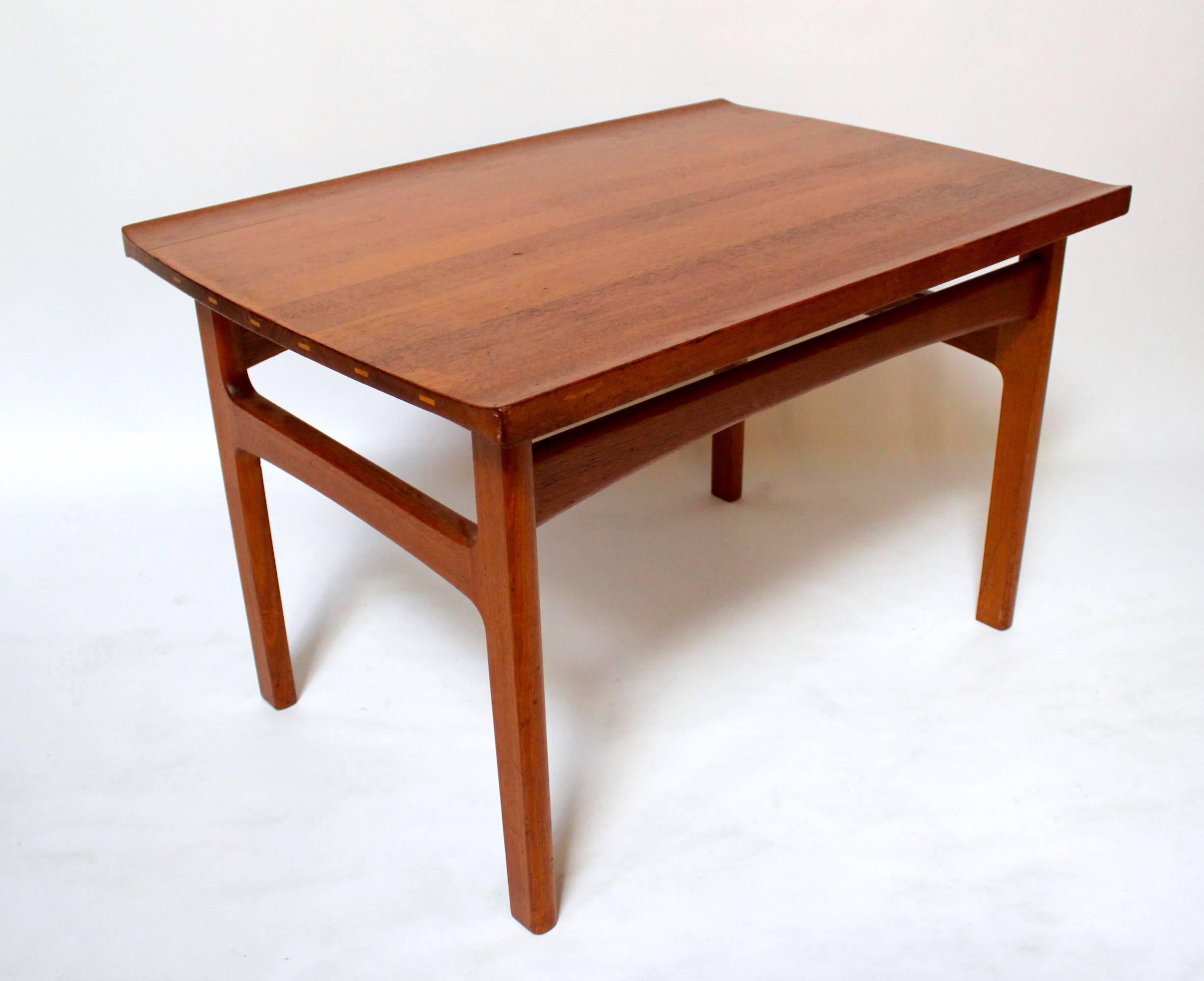 1960s Scandinavian Modern solid teak side table. Top is composed of solid teak boards with contrasting joining accents. Very nice curved accents along long sides of the top, and an almost sculptural base.
