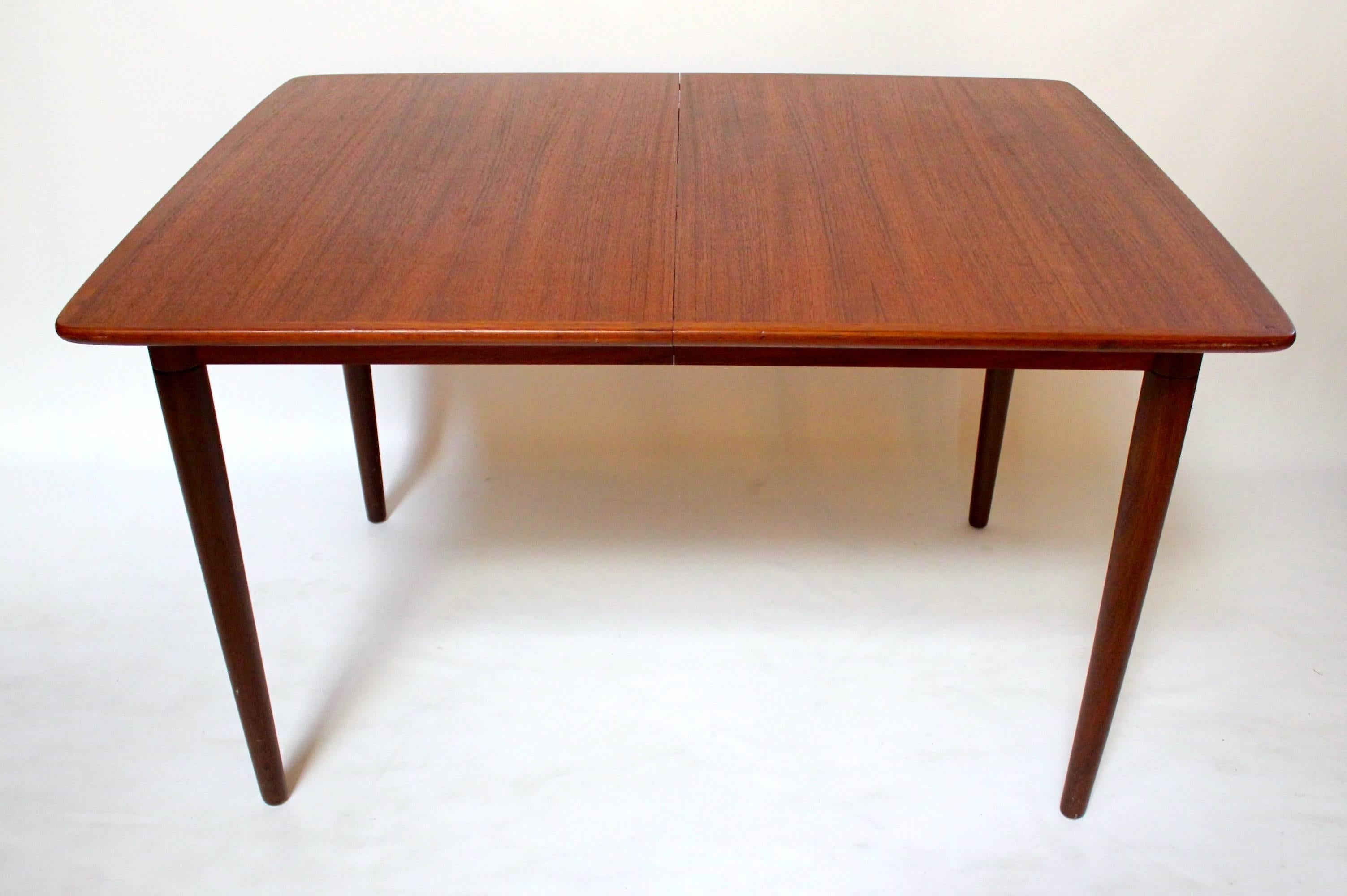 1960s Danish modern teak dining table with two leaves. Leaves store inside the table when not in use. In excellent condition with no marks or sun fading. Without leaves, the table measures 47