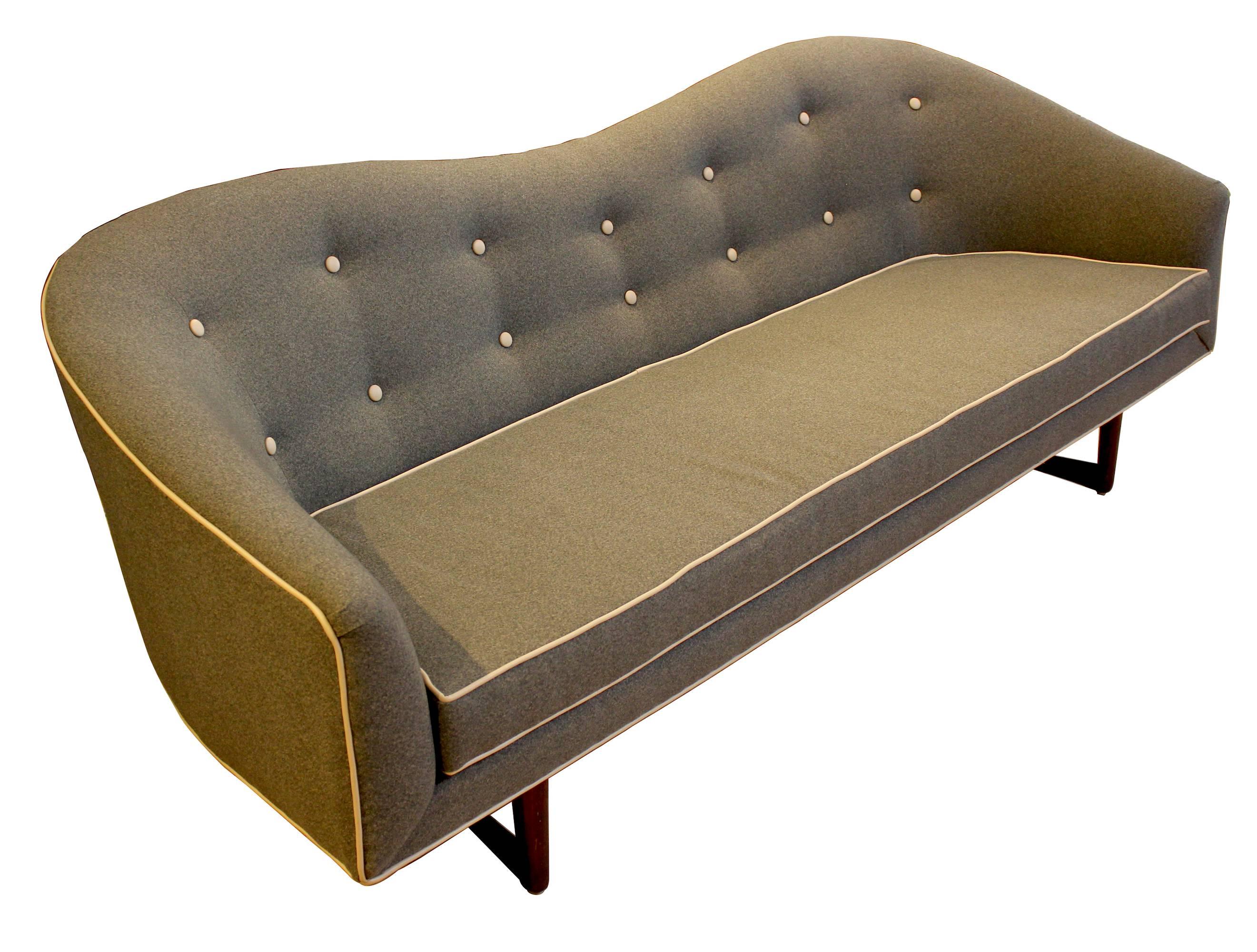1960s camelback sofa, newly reupholstered in gray felt with contrast welting and buttons.