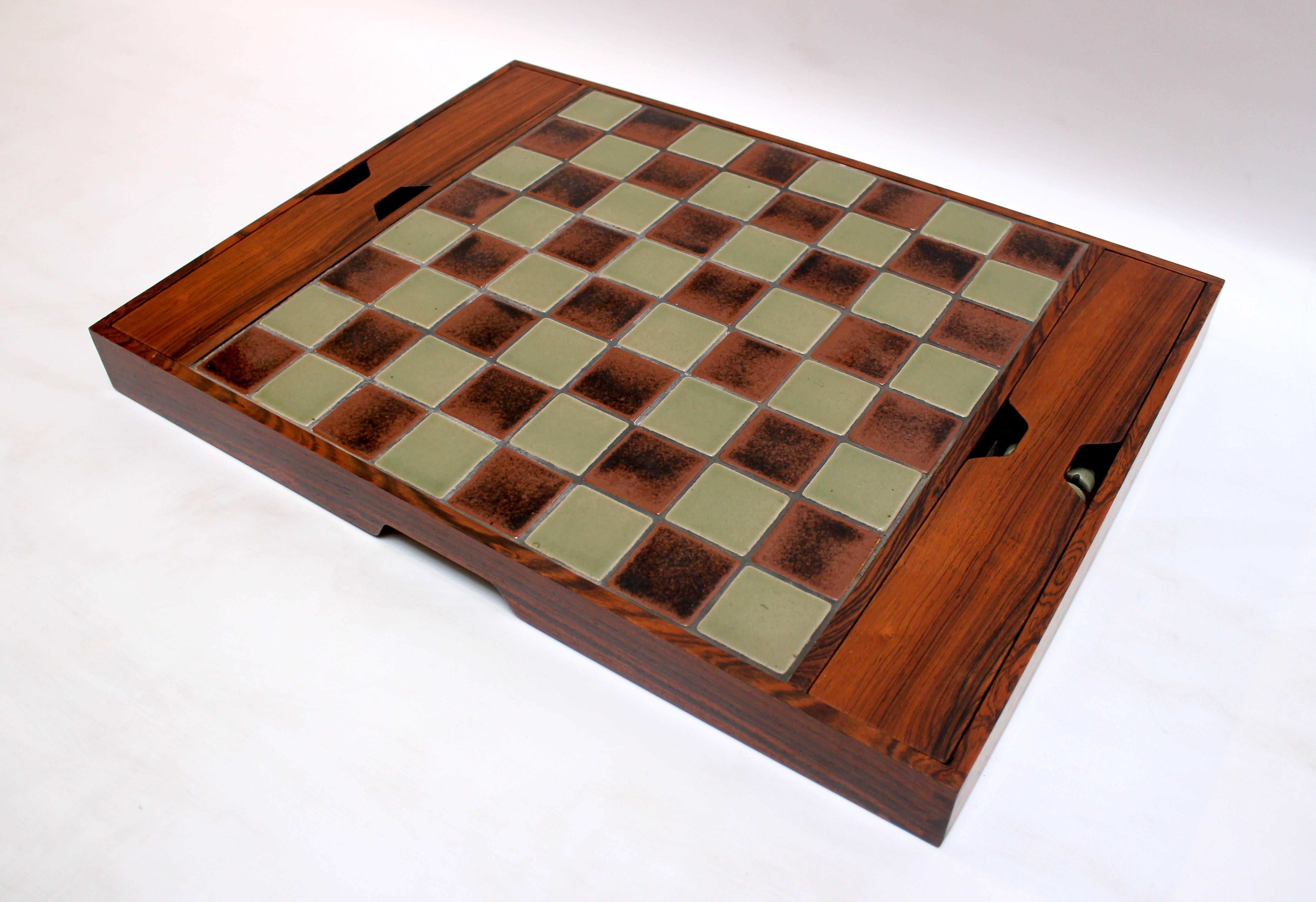 1960s Danish rosewood and pottery chess set. Game board and pieces are pottery, and pieces store in felt-lined trays in the rosewood-cased board.