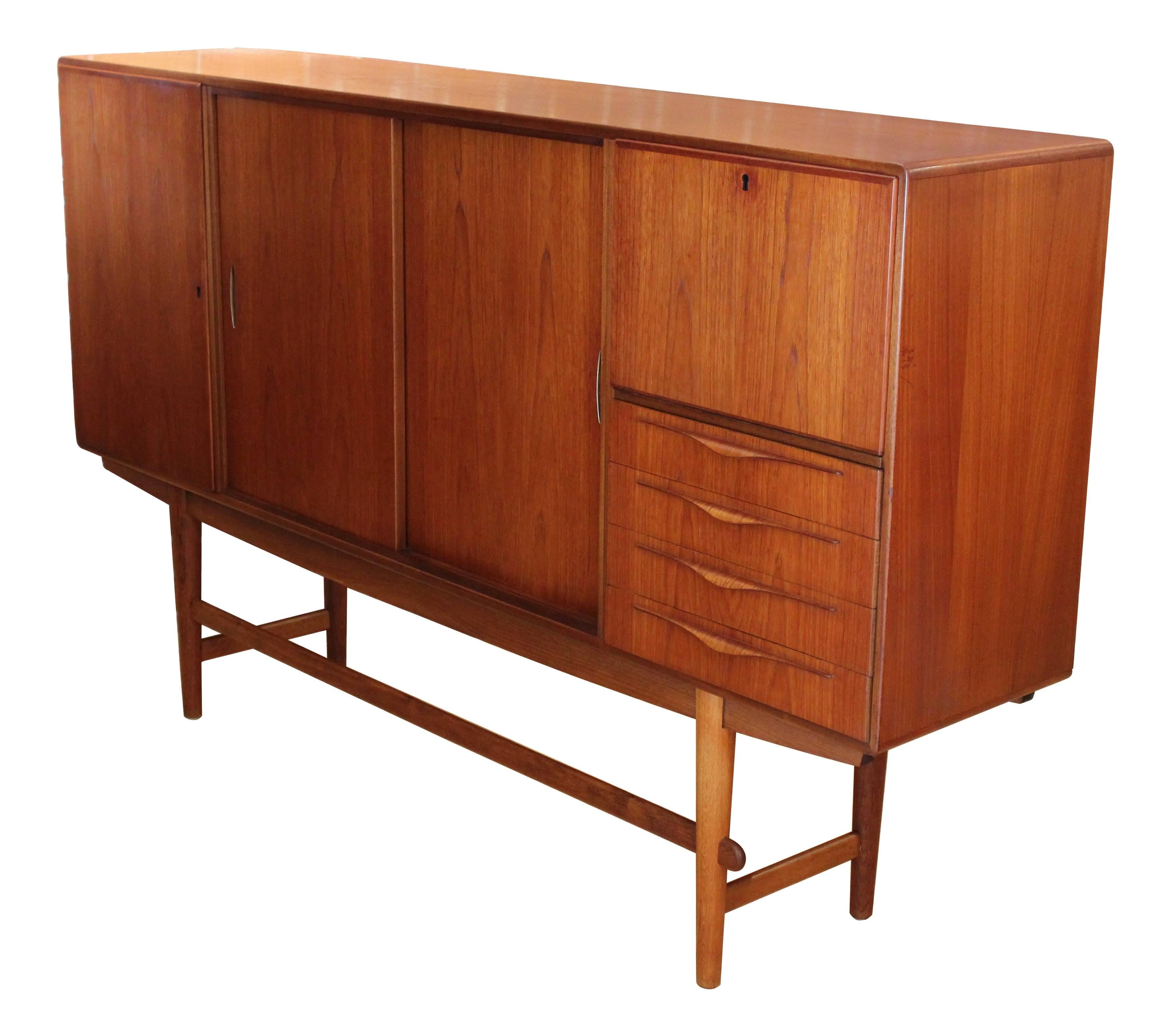Large Danish modern teak sideboard designed by Illum Wikkelso for Holger Christiansen of Copenhagen, circa 1955. A rare and beautiful design, with locking bar and locking silver cabinet (with two felt-lined drawers), heavy sliding cabinet doors with