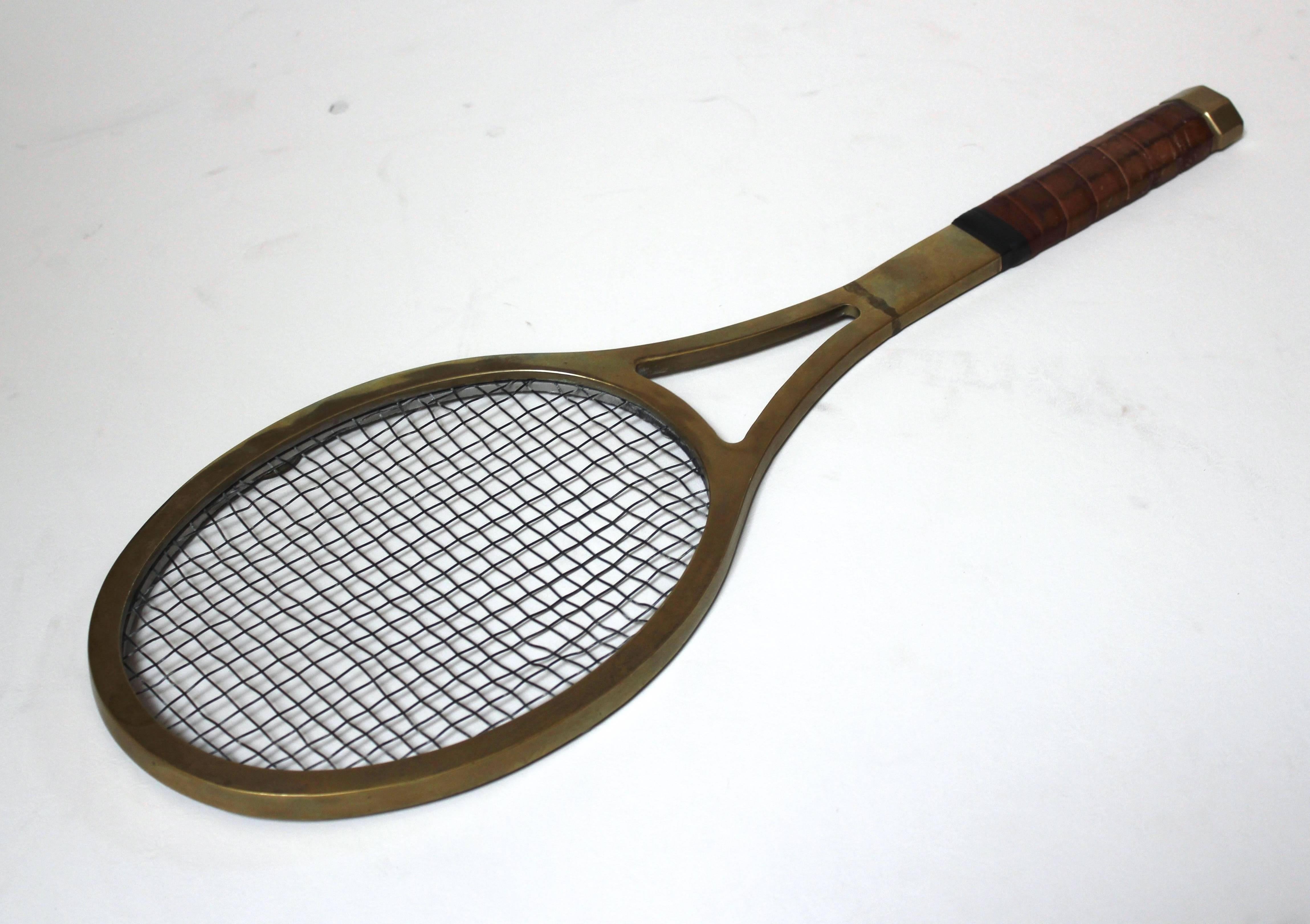 Mid-Century Modern life-sized tennis racquet wall art, with leather-wrapped handle. Hangs on an adjustable picture hook. In excellent condition.