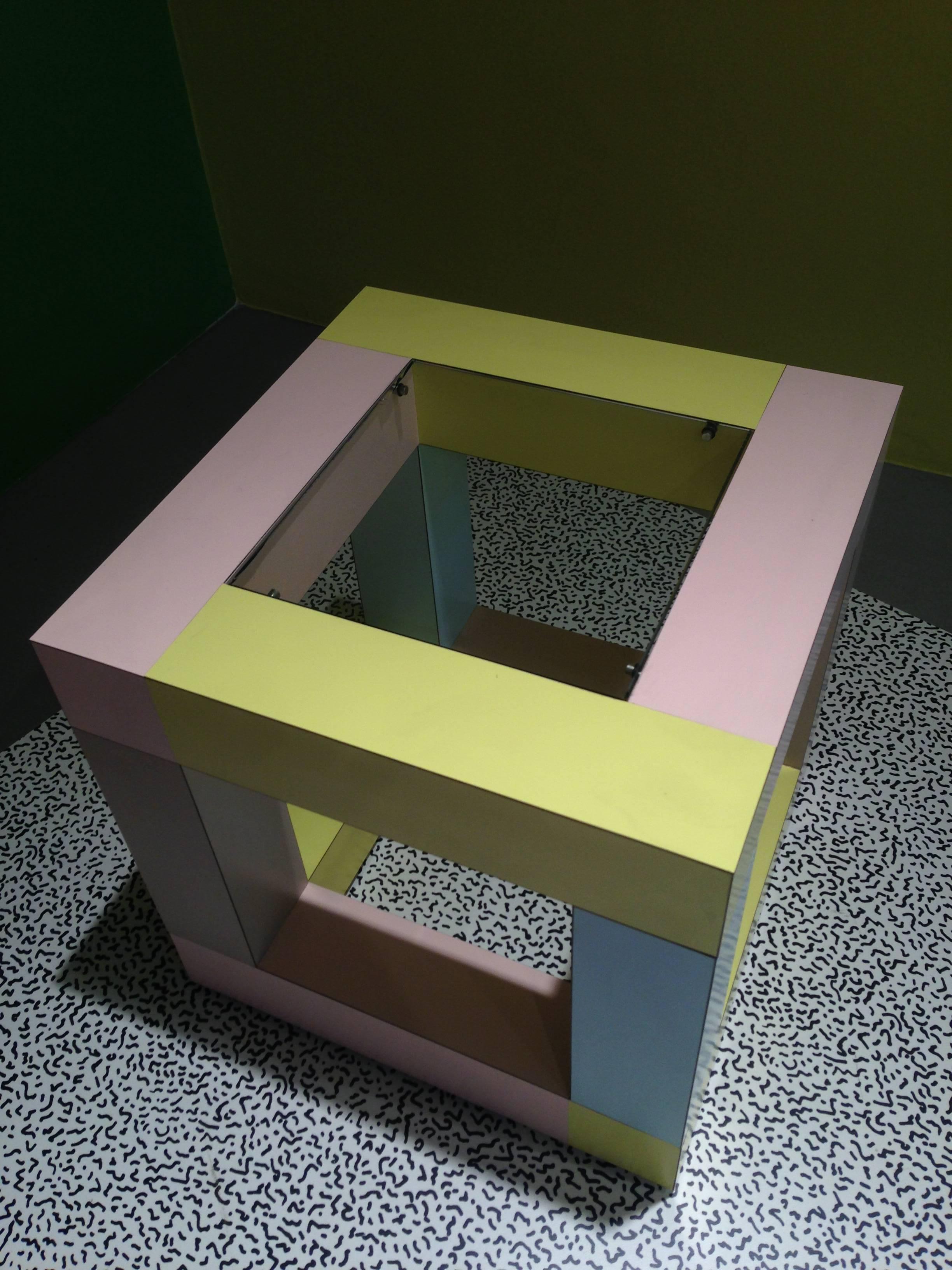 A multi-use, highly-functional end table by Ettore Sottsass for Memphis (1984). The top possesses a small inserted piece of tempered glass, otherwise leaving the piece to visually remain a perfect cube (overtones of Sol LeWitt a la Sottsass).
The