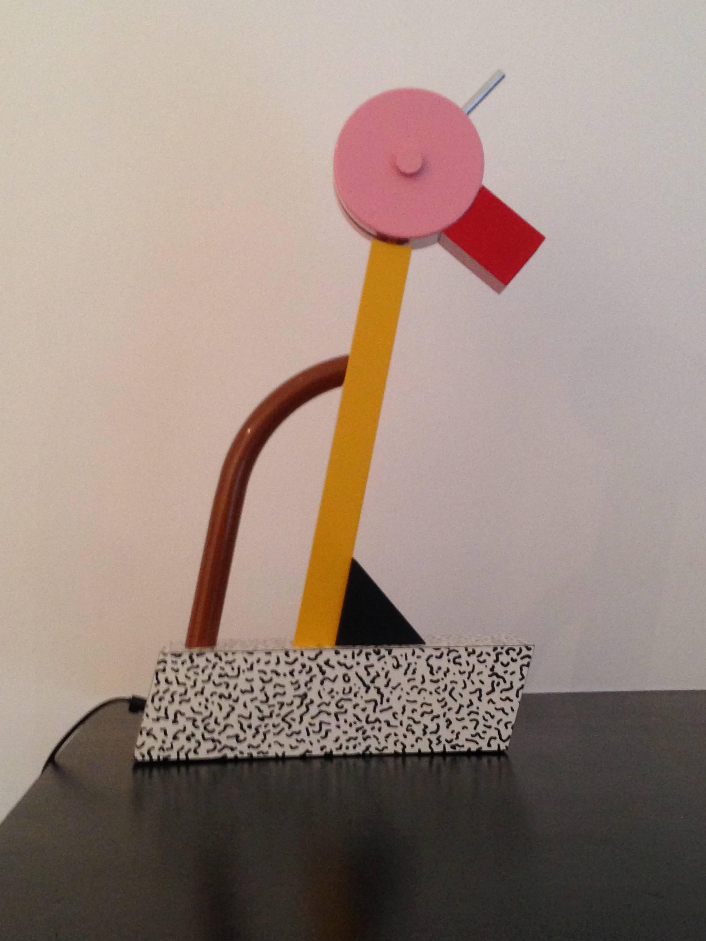 The ultimate Sottsass table light!! Anthropomorphic (looks like a parrot)!! Swivels up and down. His Sottsass-designed "Bacteriae" laminate on the base! An appendage at the back in an odd brown as a handle! A stainless grip on the pivoting