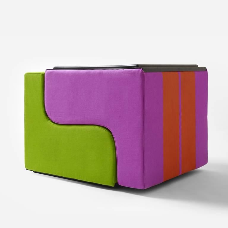 SOFO Armchair is a seat to place in a row, like a train, or to stack to build solid, colorful mountains. It is simply a block made with an S-shaped cut from a cube of polyurethane, covered with fabric featuring two large stripes. The result of a