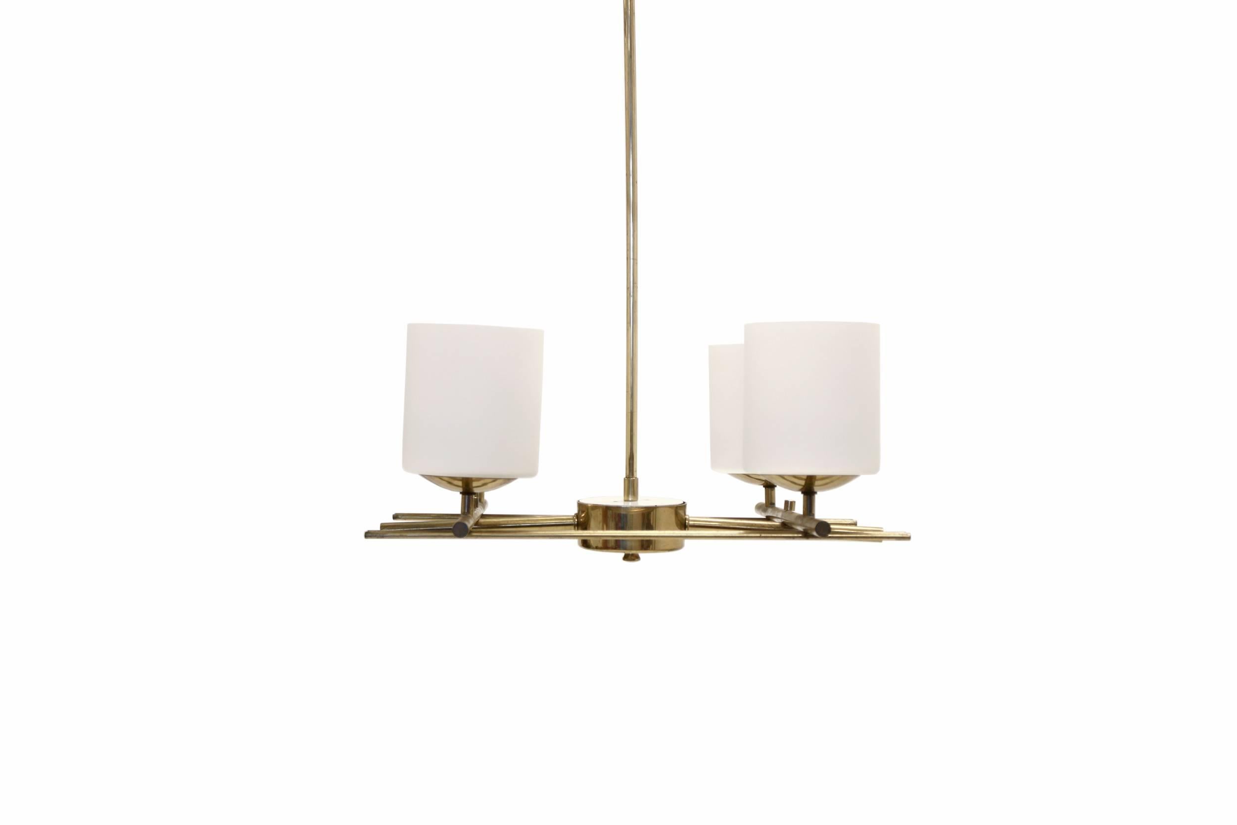 Modernist and visually striking four-armed chandelier in brass and opaline glass. Designed and manufactured in Finland by Itsu, circa 1960 first half. The lamp is fully working and in excellent vintage condition.