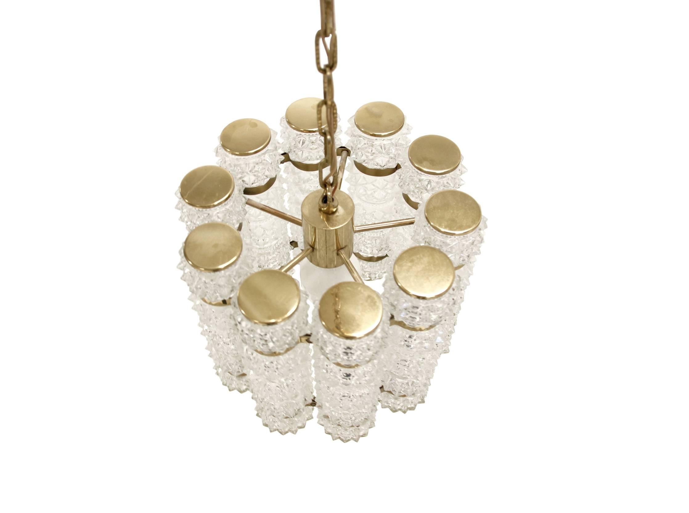 Decorative and well made chandelier with ten cylinder shaped cupolas in crystalized glass and brass fittings. Designed and manufactured in Norway by Tyringe Lys, circa 1970s first half. The lamp is fully working and in very good condition. It is