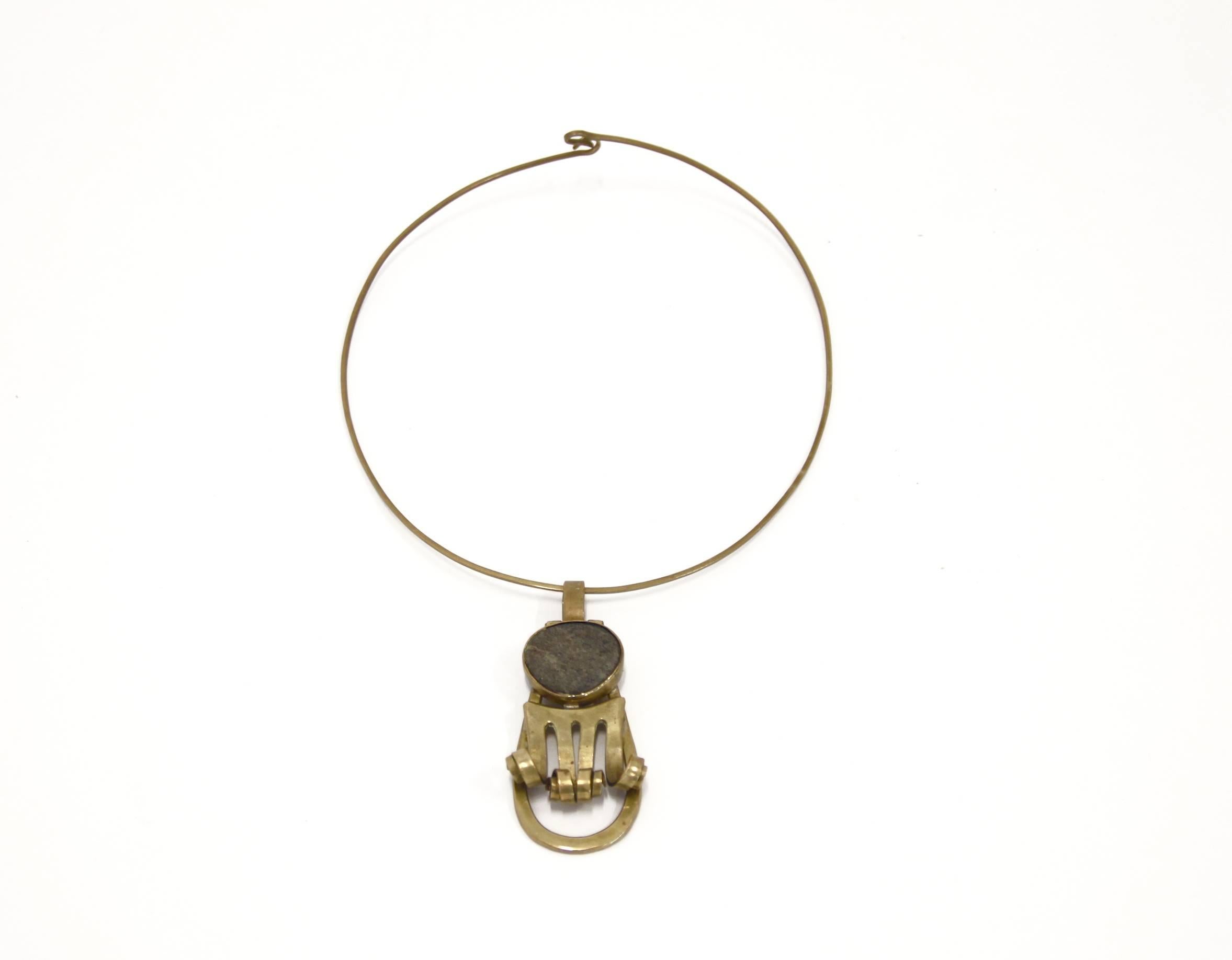 Incredibly rare studio necklace by modernist jeweler Anna Greta Eker. The necklace is beautifully sculptured in brass with a Norwegian mountain stone. Eker's intense and modernist expression is minimalist yet highly structured. Eker was inspired by