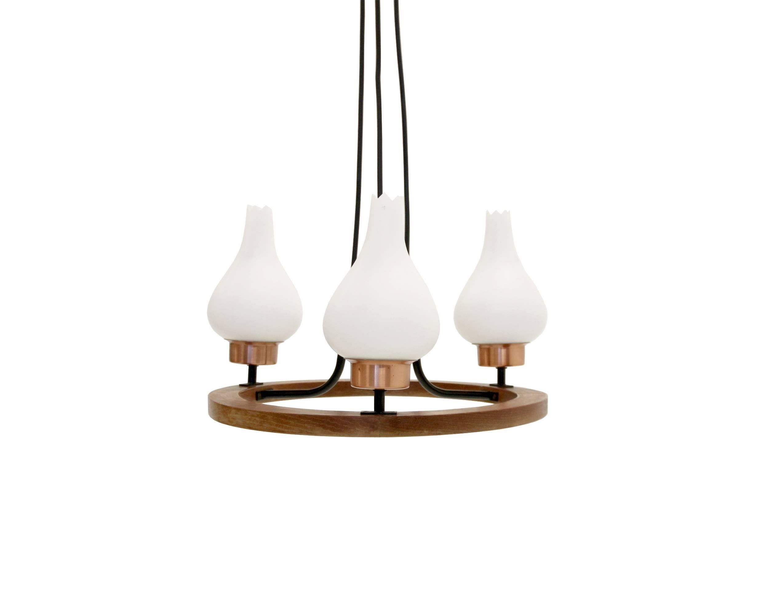 Remarkable and well made chandelier on a teak frame with three opaline glass shades.

Most likely designed and manufactured in Norway, circa 1960s second half.

The lamp is fully working and in good vintage condition.