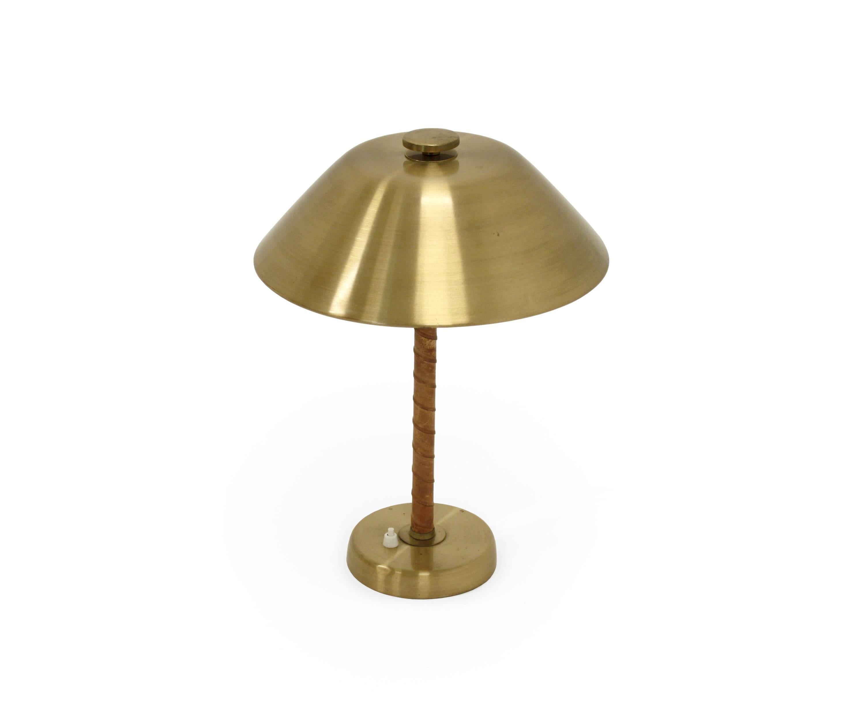 Graceful and modernist table lamp in brass and natural tanned leather.

Designed and made in Sweden by Einar Backstron, Malmo, from 1960s second half. 

The lamp is fully working, it has new wiring and is in excellent vintage condition.

