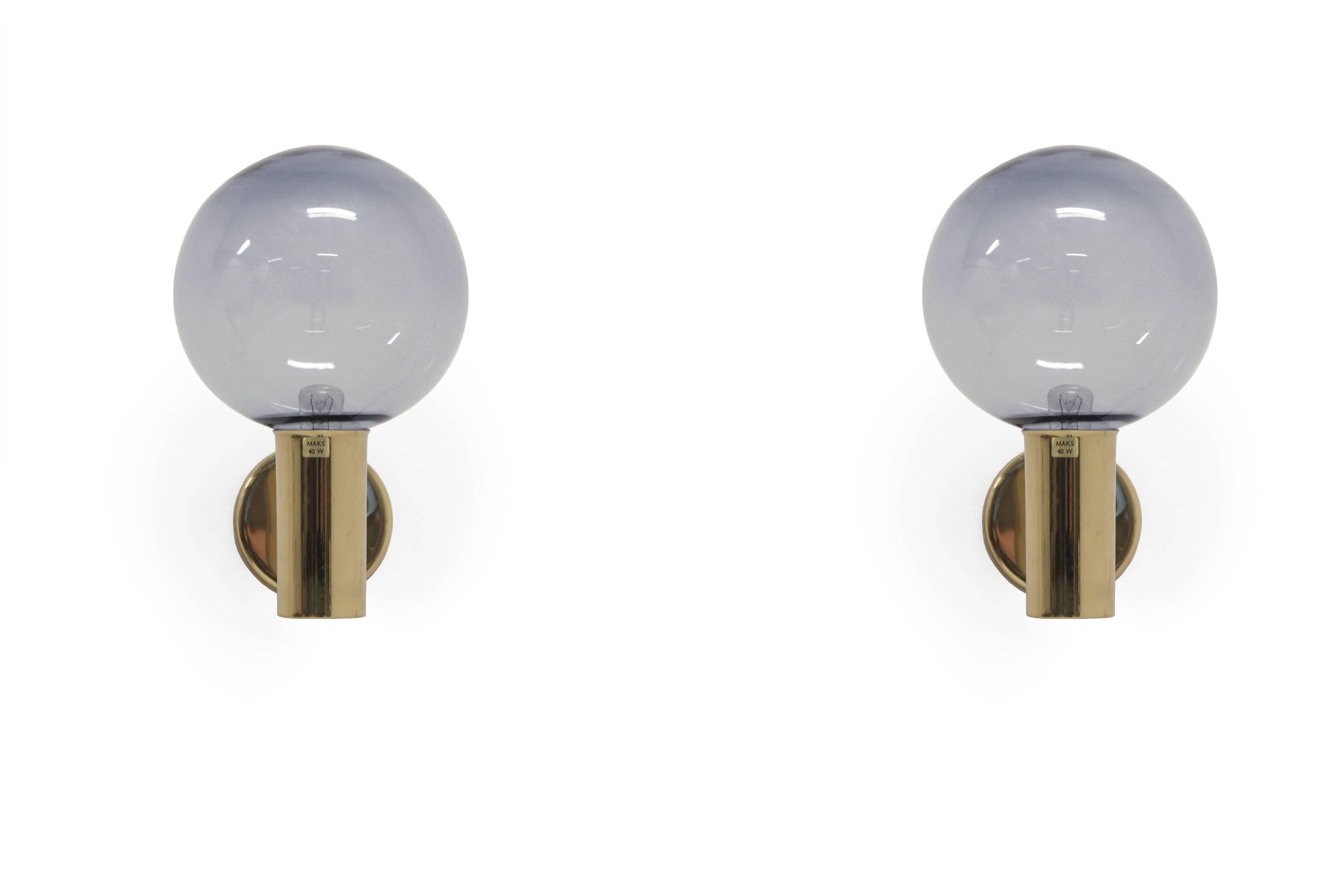 Beautiful pair of wall lights in brass and shades in glass with a blue tone.

This is model V-149. Designed by Hans Agne Jakobsson and made in Norway on license by Arnold Wiigs Fabrikker, from circa 1960s second half.

Both lamps are fully
