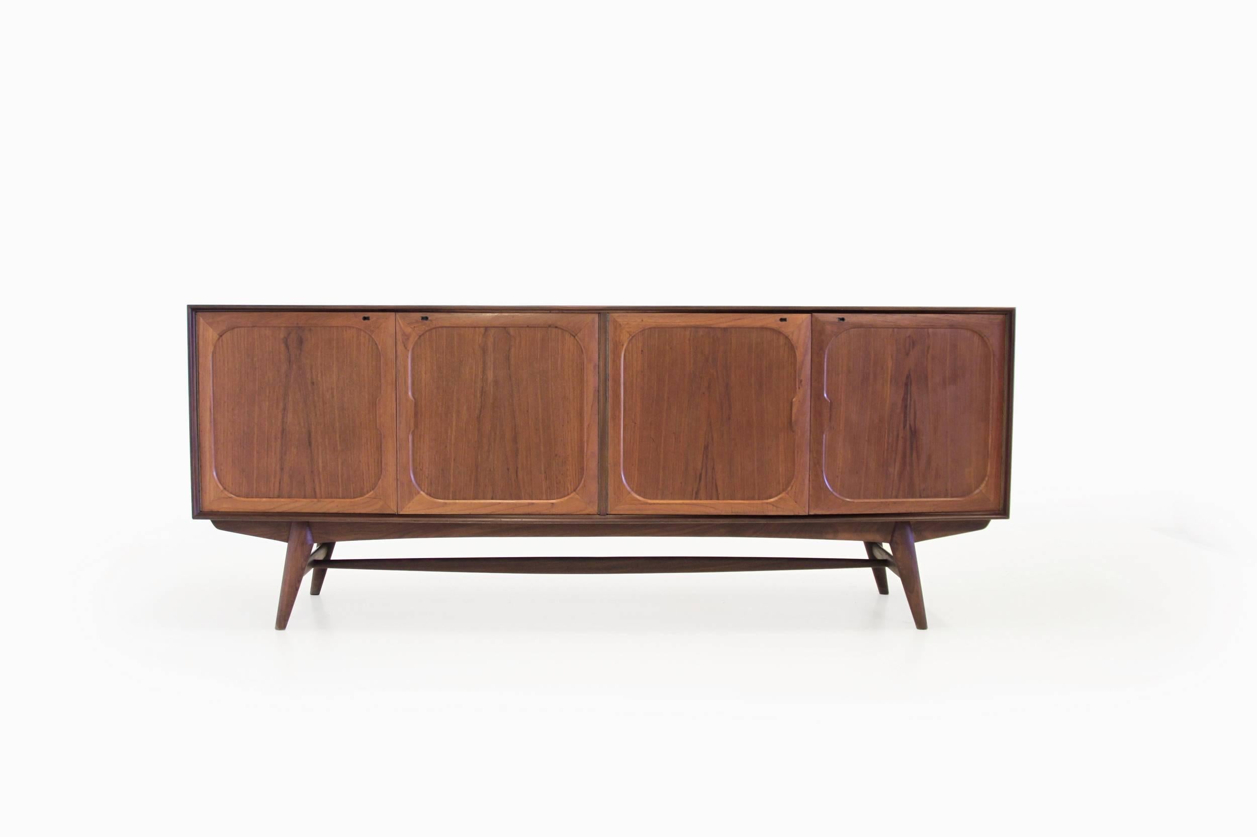 Large and Minimalist sideboard on a teak frame, four doors and four drawers. Designed by Adolf Relling and Rolf Rastad and manufactured in Norway by Gustav Bahus eftf. The sideboard is in excellent condition with normal age related wear and minor