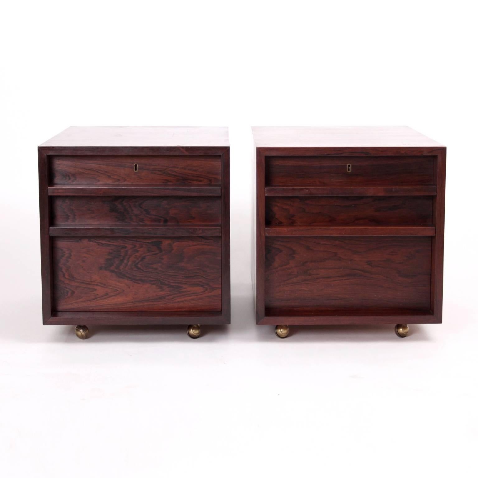 A rare pair of Brazilian rosewood cabinets or side tables designed by Bodil Kjaer in 1959.

With rosewood both front and back. Front with two locking drawers. Mounted on brass casters.

Produced by E. Pedersen & Søn 1960s.

Excellent