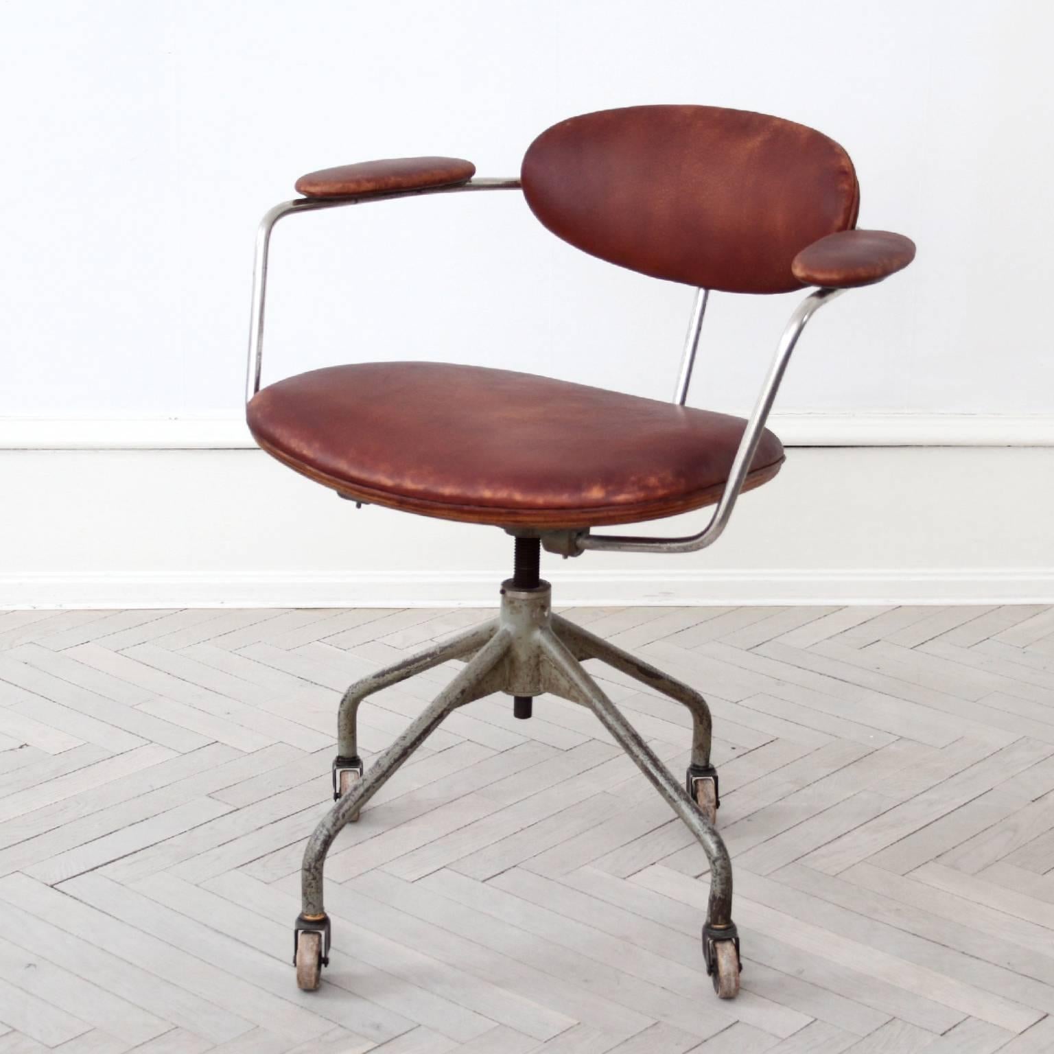 An extremely rare swivel chair, model B 621 designed by Hans J. Wegner.

Top with chromed steel, gray painted height adjustable base mounted on castors. Seat, back and armrests upholstered with brown leather, reverse side of seat and back with