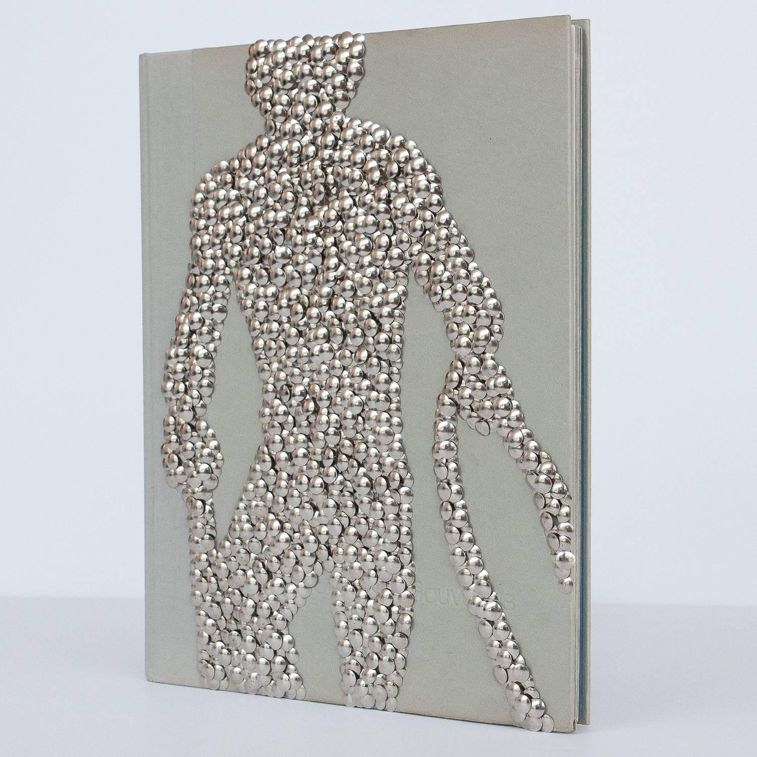 Hand gilded copy of Ken Haak's Summer Souvenirs photography art book with silver thumbtacks forming a male nude on the front cover by Chicago artist Brian Stanziale.

Sculptural and playful, 