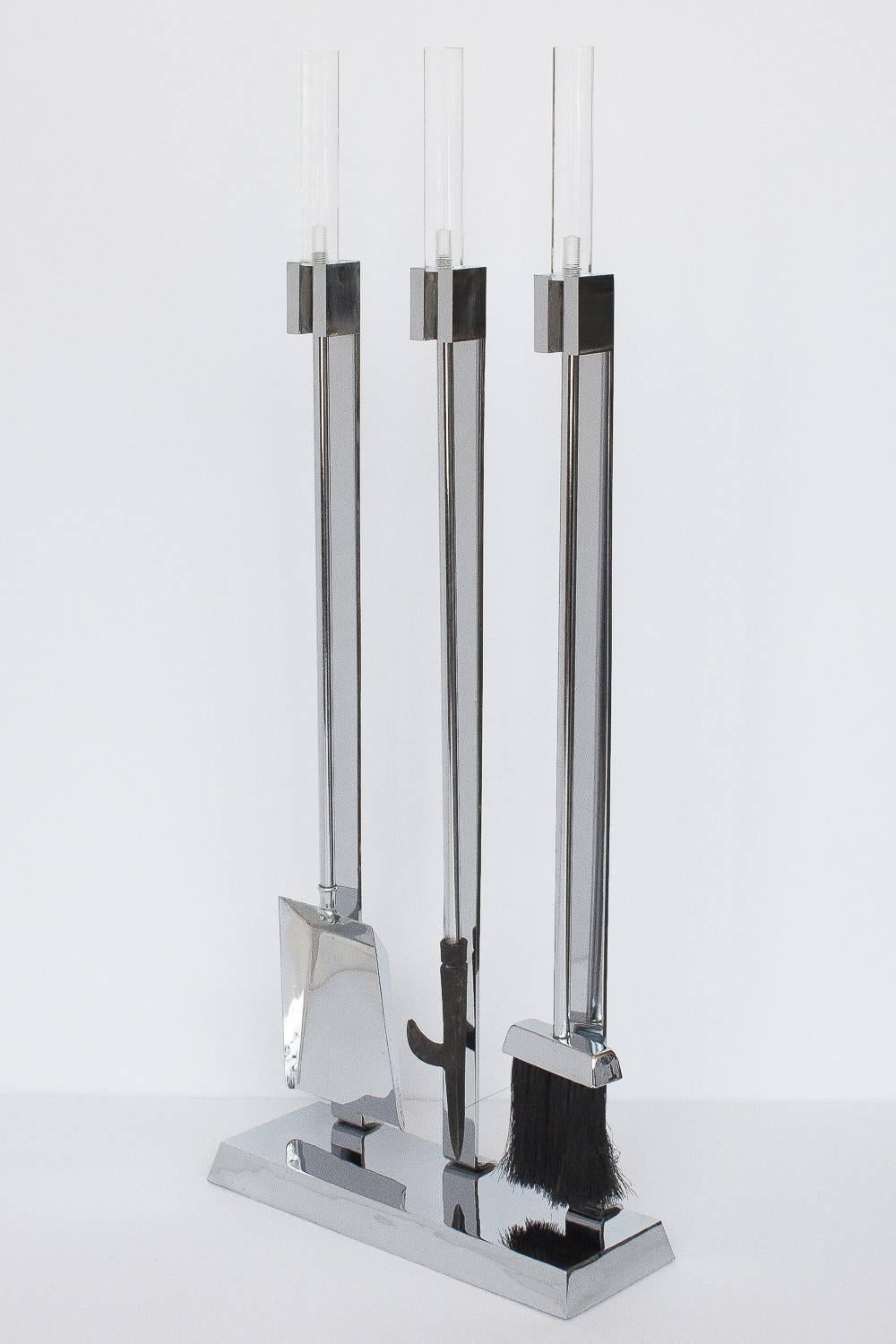 1970s, modernist Lucite and polished chrome fireplace tool set. Measures: 5.5" long, 1" diameter clear Lucite handles. Polished chrome rectangular base and three flat bar supports. Very good condition with a couple of tiny chips to the