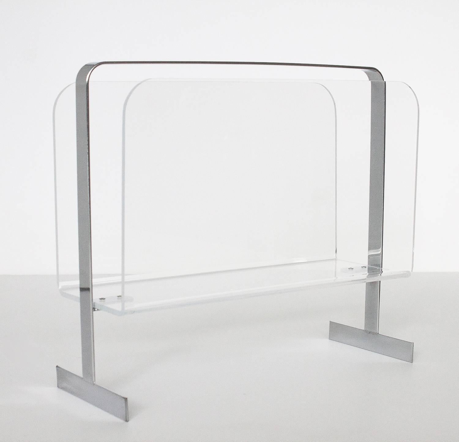 Stylish 1970s magazine rack attributed to Milo Baughman. Comprised of bent Lucite and supported by a chrome frame terminating in bracketed feet.