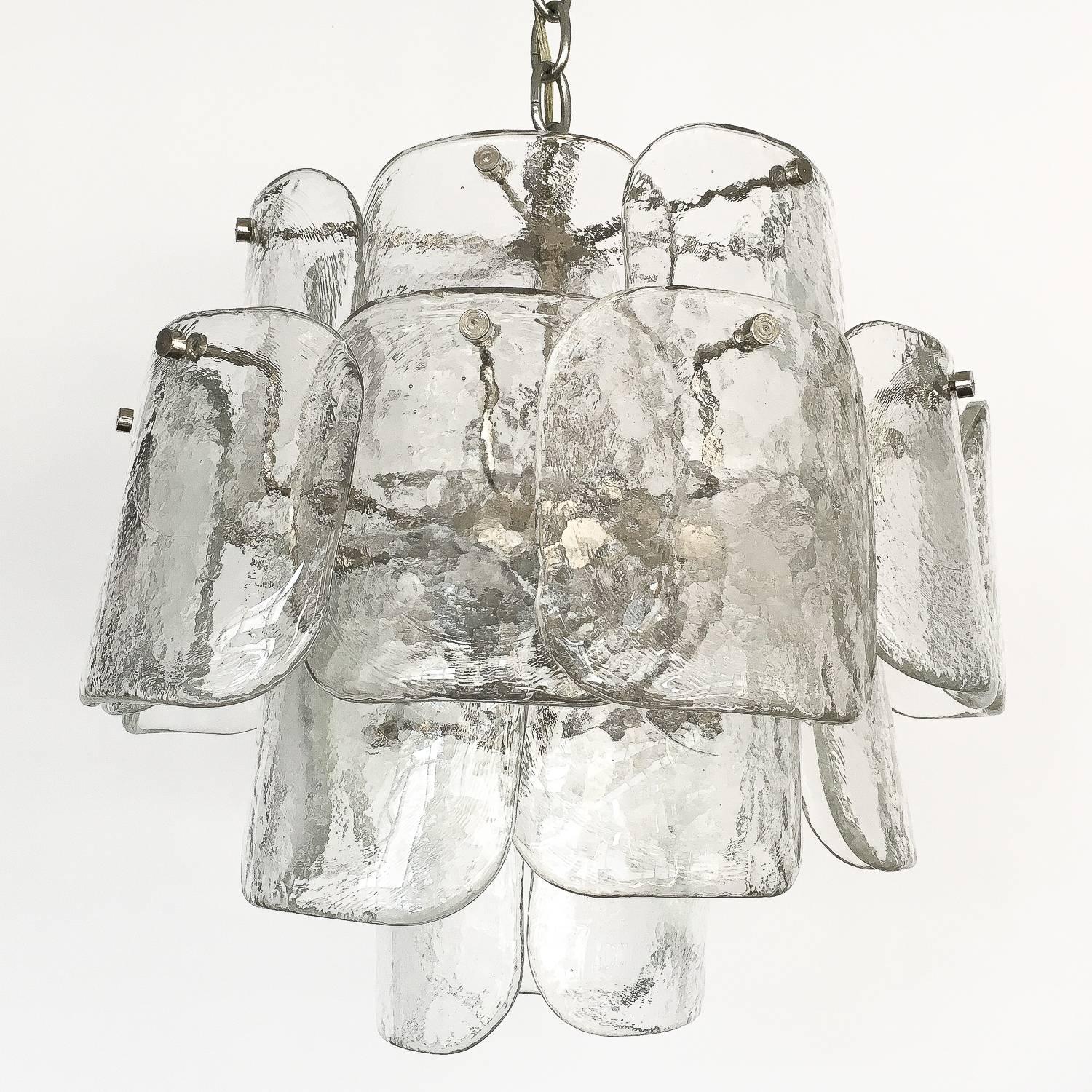 A Mazzega four-tier clear Murano glass chandelier. Consisting of 26 curved petal or 