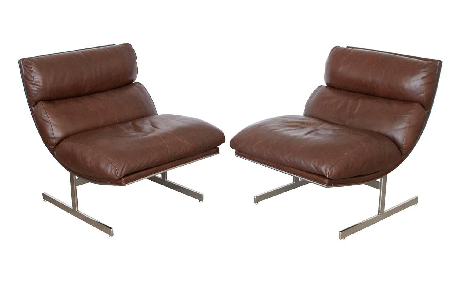 Pair of Kipp Stewart chrome and leather lounge chairs for Directional. Unique scoop curved design. Original chocolate brown leather. Chrome-plated seamless steel frames which frame the entire back of the chair. Beautifully broken in leather shows