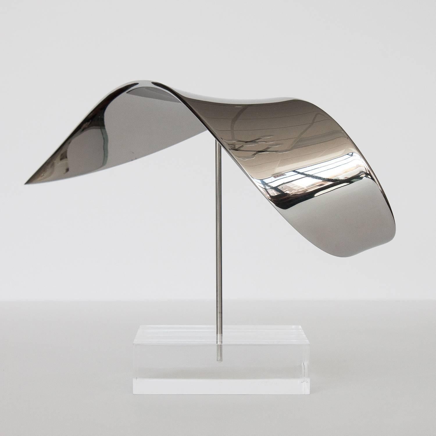 A balanced kinetic sculpture of polished solid steel sitting on a 1.5