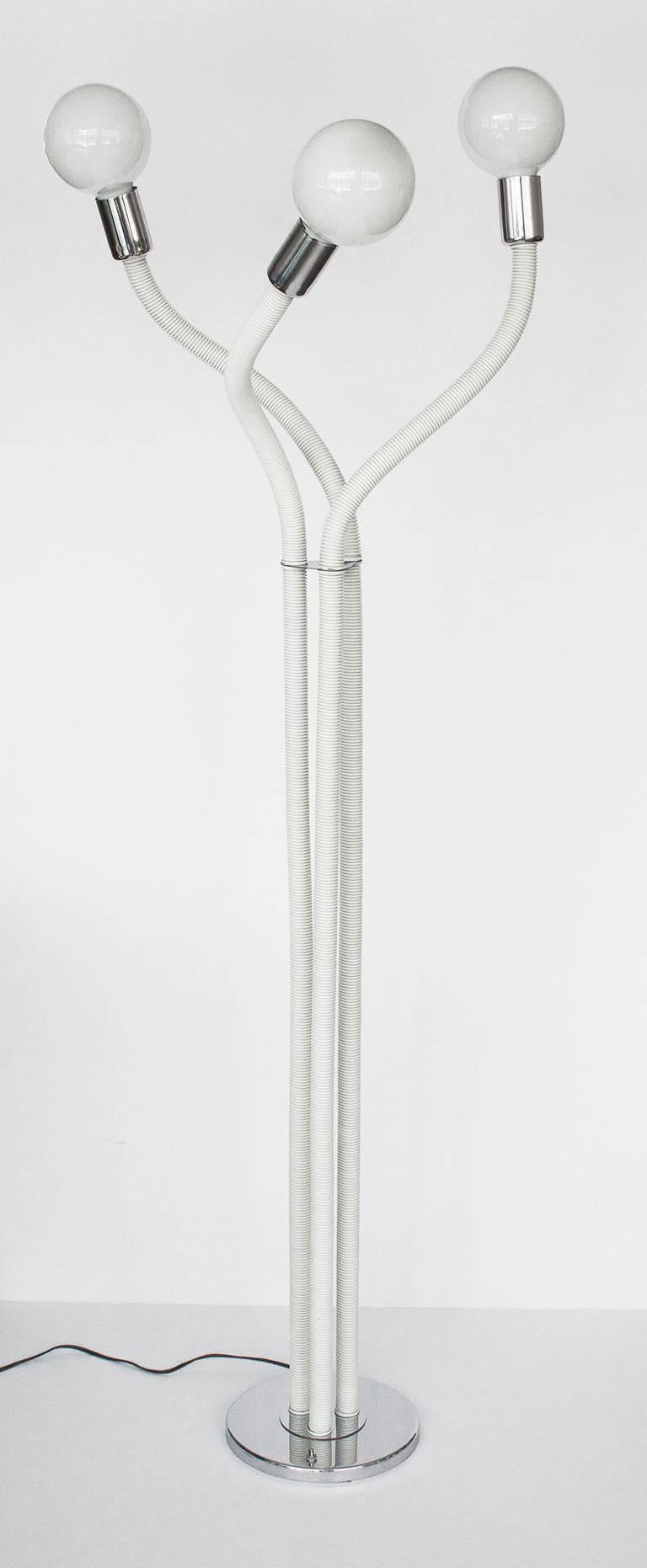 This unique floor lamp is comprised of three flexible arms that can be arranged and configured creating a playful effect. Unlimited possibilities! Each arm ends with an exposed light bulb and chrome socket. Sculptural free-form floor lamp in the