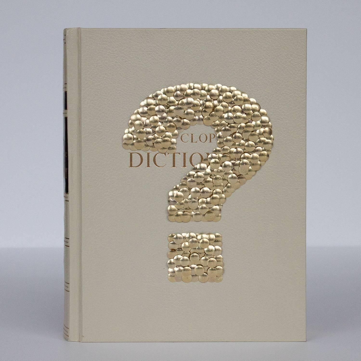 Hand gilded copy of Funk & Wagnalls - 1972 Standard Encyclopedic Dictionary with brass thumbtacks forming a question mark on the front cover by Chicago artist Brian Stanziale. 

Sculptural and playful, 