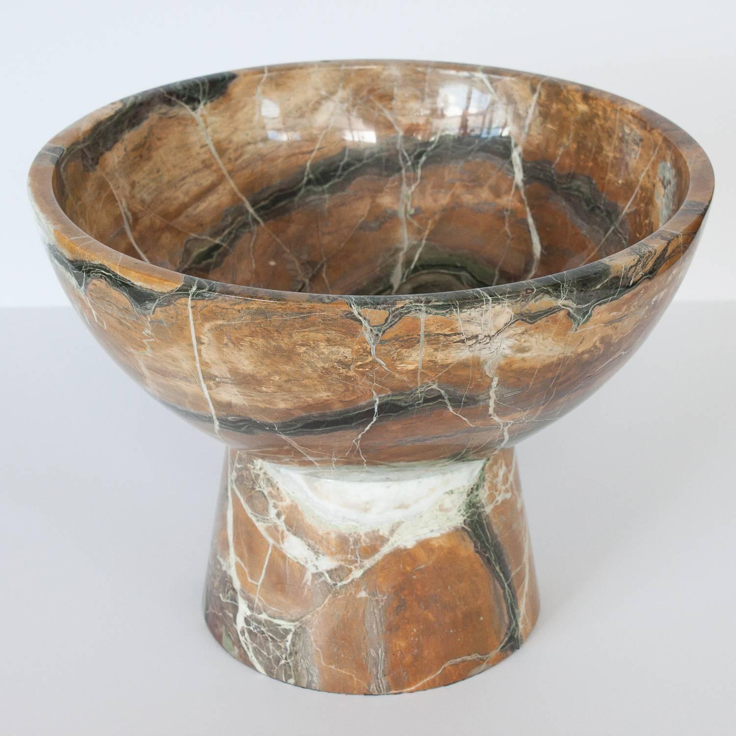 Stunning monumental solid marble pedestal bowl. Solid marble base with turned 5/8' thick round marble bowl. The stone is in earth-tones of brown, caramel, white, green and tan. Polished finish. Great scale as a centerpiece on a dining table.