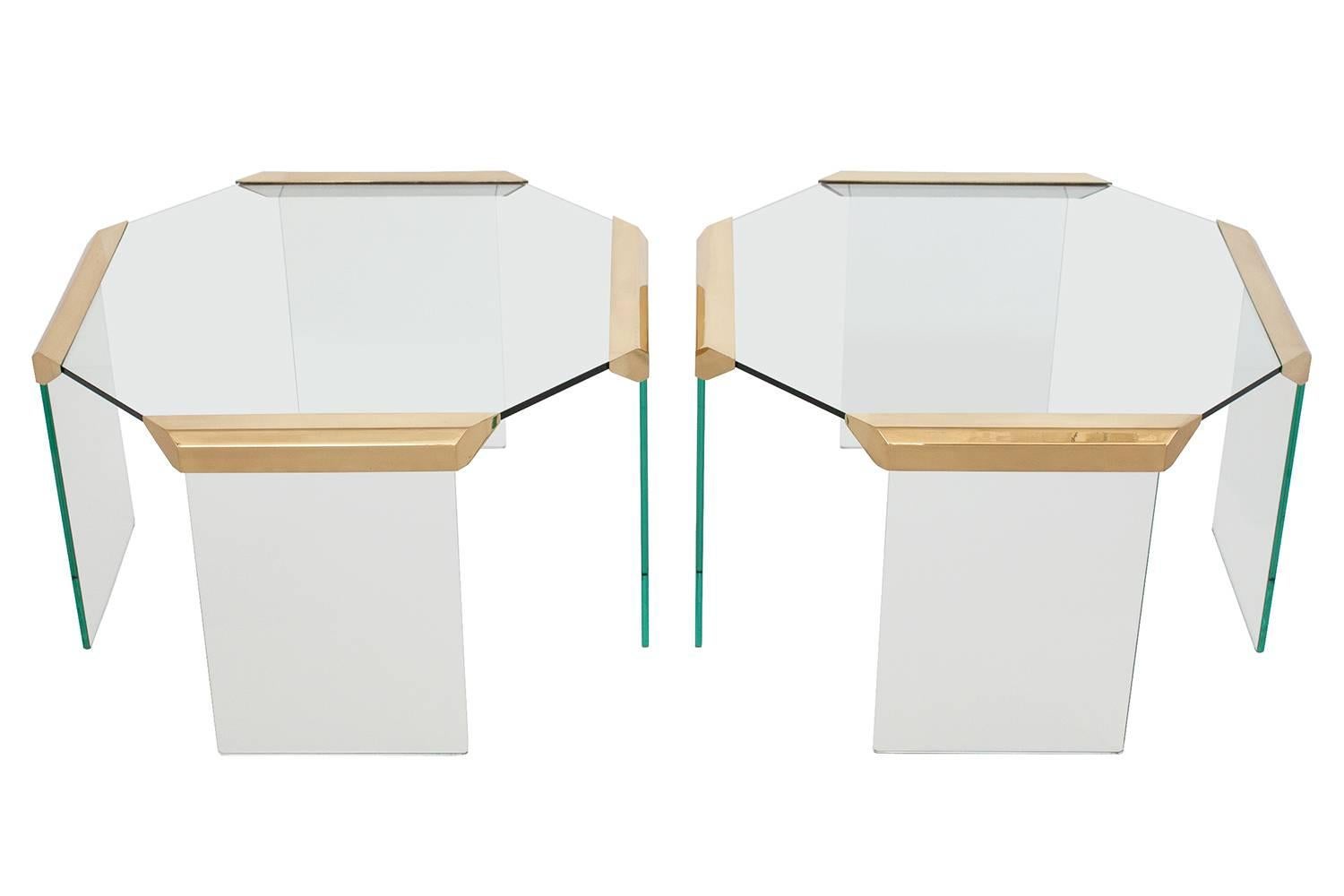 Fabulous pair of brass and glass octagon shape waterfall end tables in the style of Pace. 1/4" thick glass top and legs. Radius edge to glass legs at floor. Four unique faceted brass joints to each example. Excellent as a pair of side tables or