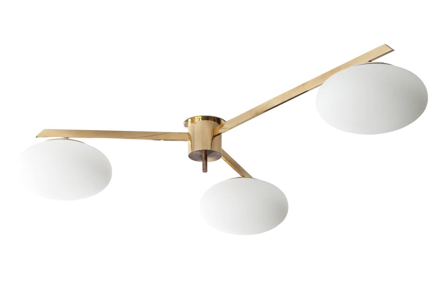 Three-arm ceiling light by Angelo Lelli for Arredoluce, Italy. This chandelier is composed of an all brass frame with three compressed frosted white glass globes. Asymmetrical design as each arm is a different length. An original extra 4th