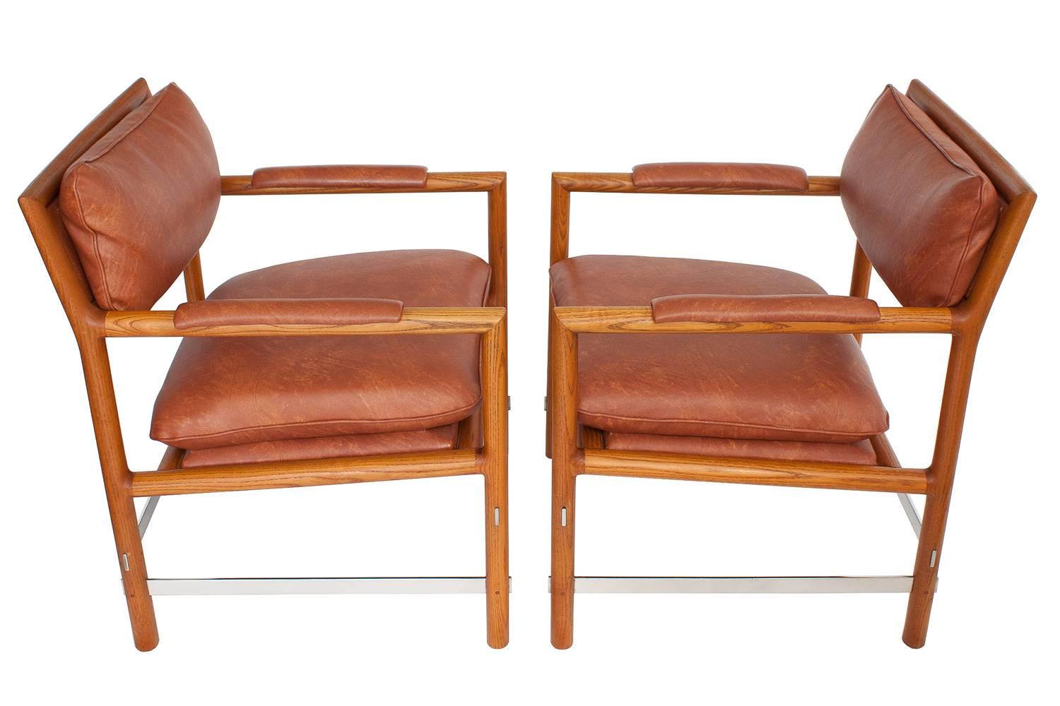 Pair of Dunbar armchairs, circa 1960s by Edward Wormley (1907-1995.) Known as "Edward's Chair," these handsome examples have oiled ash wood frames and stainless steel stretchers. These chairs have been recovered at some point in time in a