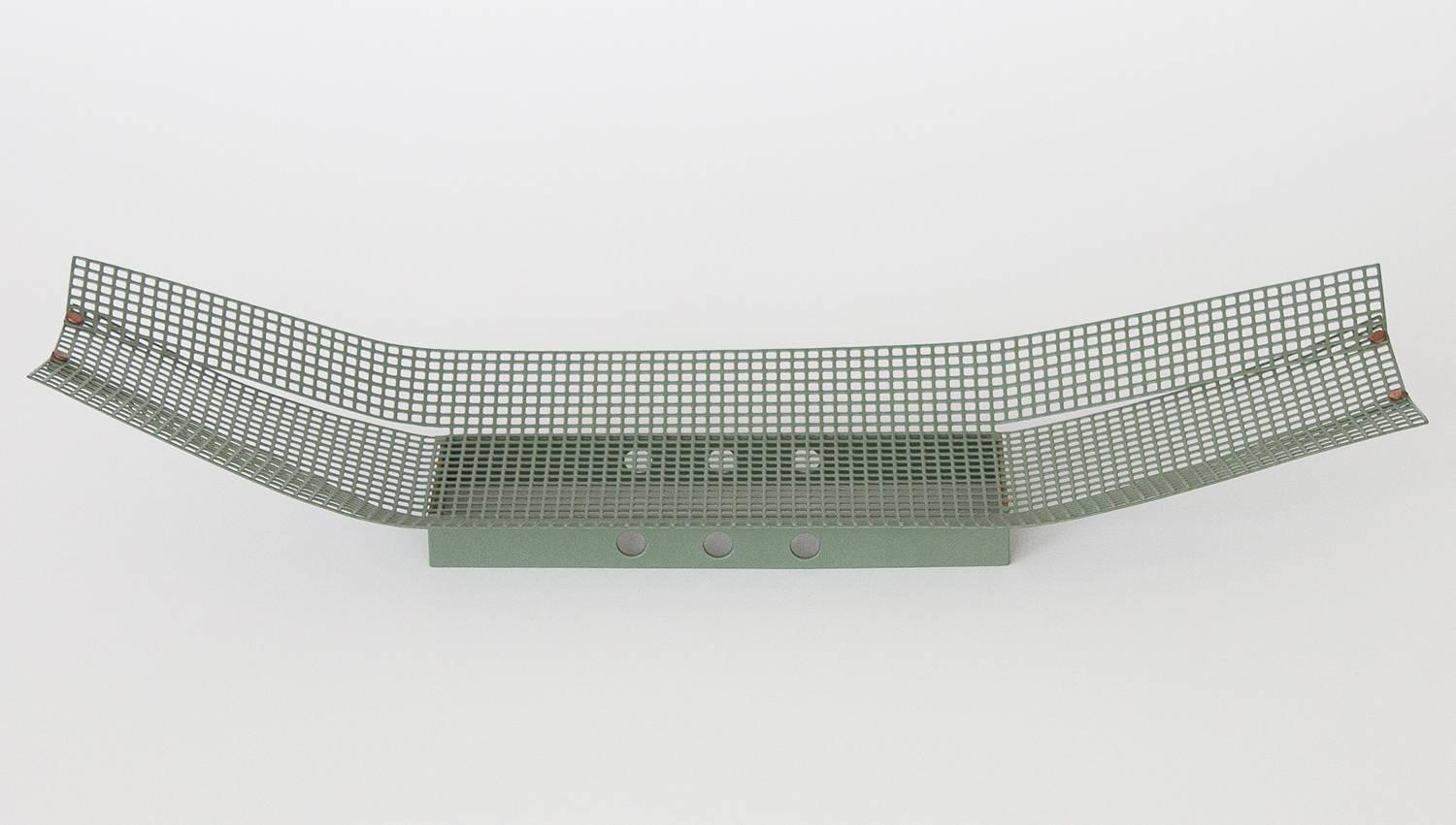 Unique modernist muted green enameled perforated metal tray or bowl. Grid perforations. Industrial postmodern design. Overlapping folded metal ends create a boat shaped design and are held in place by copper rivets. Rectangular metal base with