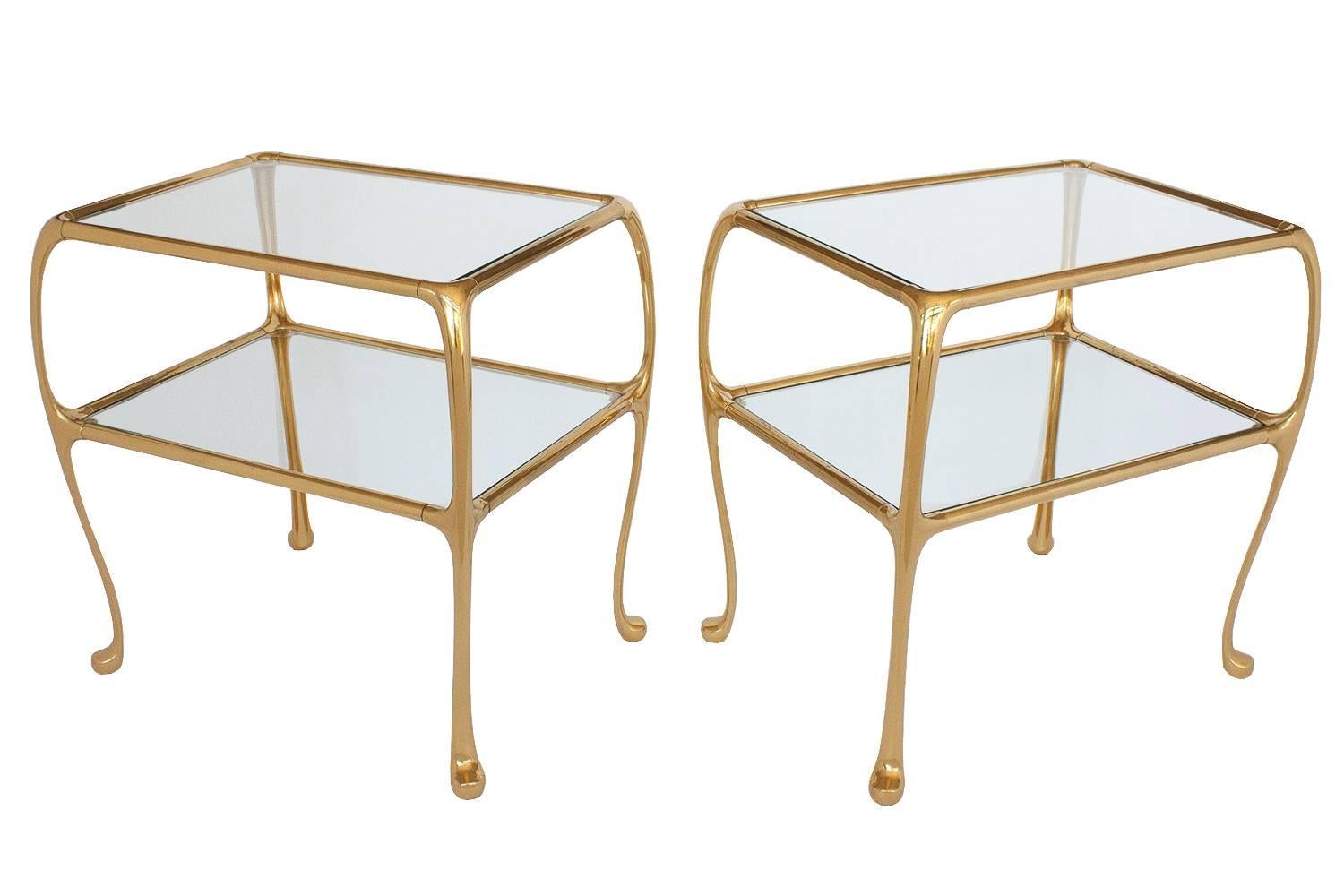 Pair of Gaudi/Art Nouveau inspired brass two-tier end tables. Curvaceous stylized modern Queen Anne legs. Inset glass top and lower shelf. Lower tier measures 13" H. Consider using as end tables or pair of nightstands.