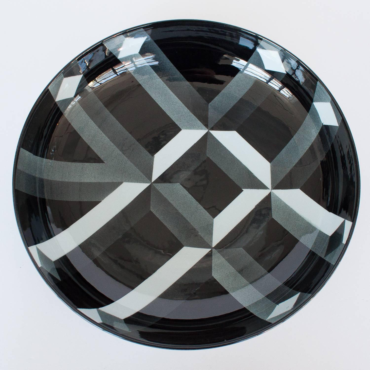 A large beautiful modern porcelain bowl by Rolf Sinnemark for Rörstrand, Sweden. Atlantis series. The black glazed bowl is decorated on the exterior and interior with printed geometric forms in shades of gray. Signed to bottom.
 