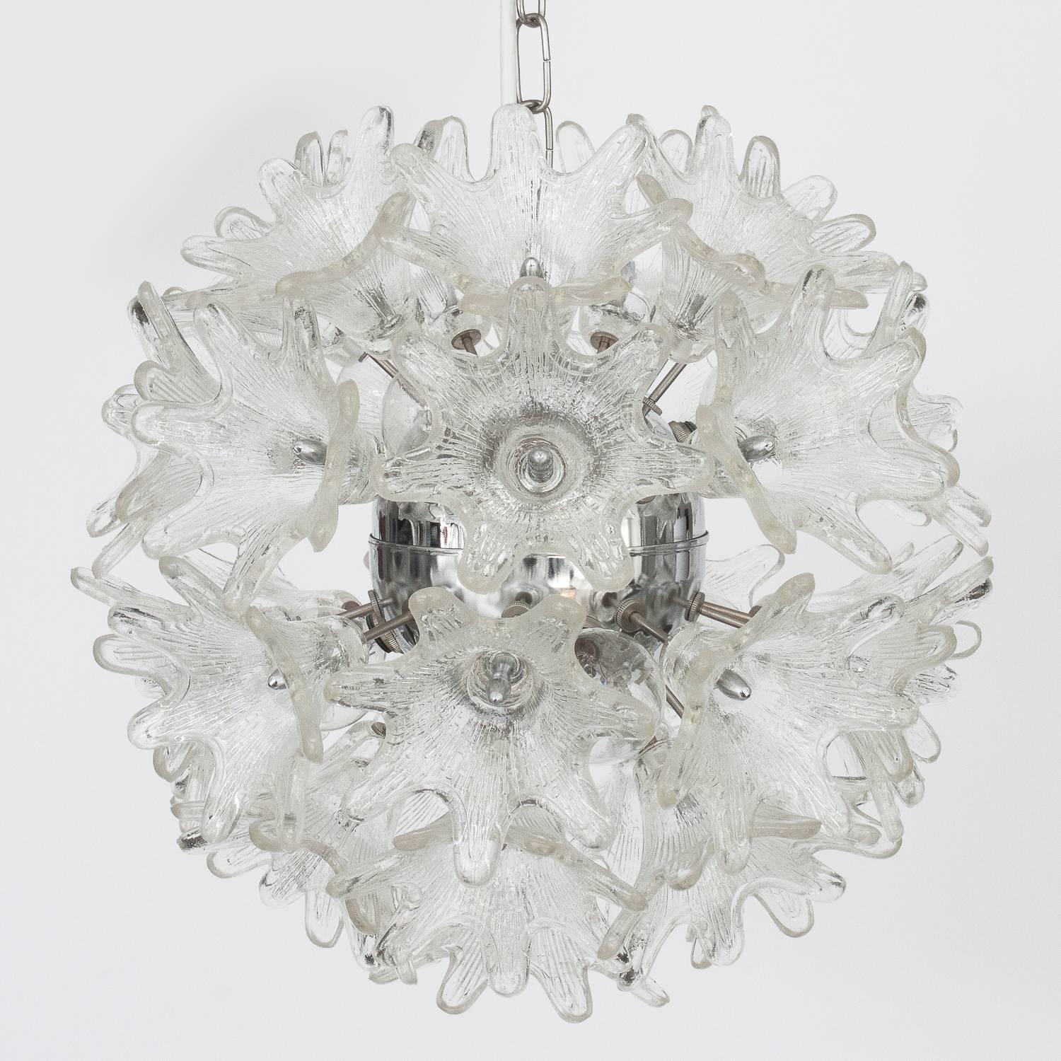 This Italian floral sputnik pendant chandelier features 33 textured Murano glass flowers on each example radiating from a central chrome hub. Each fixture takes six candelabra base light bulbs. Chrome chain and 5" diameter chrome canopy for