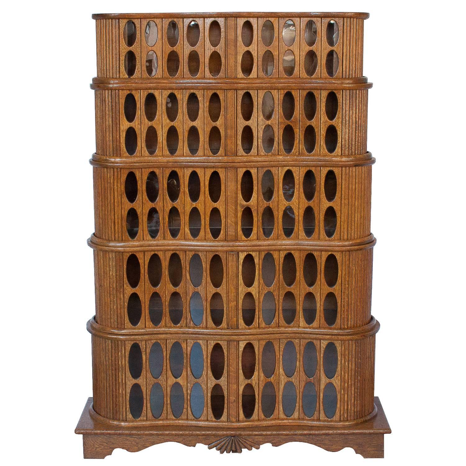 Striking and unusual this 1930s solid oak cabinet features a stacked barrister inspired design with elliptical shaped glass windows. Bridging the Arts and Crafts movement and modernism, this cabinet shows the craftsman's woodworking skills and