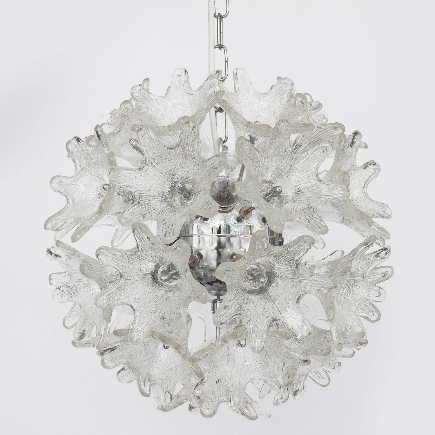 This Italian floral Sputnik pendant chandelier features 33 textured Murano glass flowers on each example radiating from a central chrome hub. Each fixture takes six candelabra base light bulbs. Chrome chain and 5" diameter chrome canopy for
