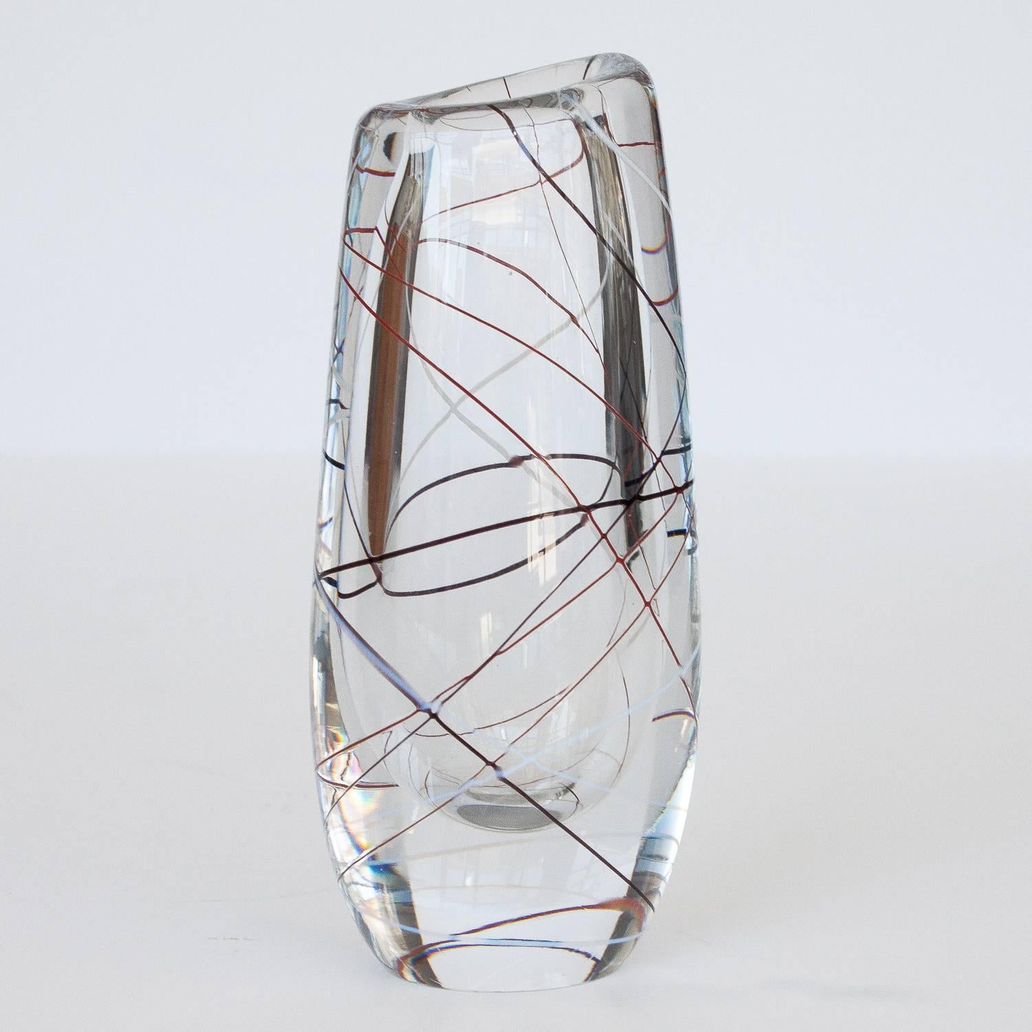 Clear glass vase decorated with crisscrossing glass threads in black, red and white by Vicke Lindstrand for Kosta. Engraved "Kosta LH 1089". 

 