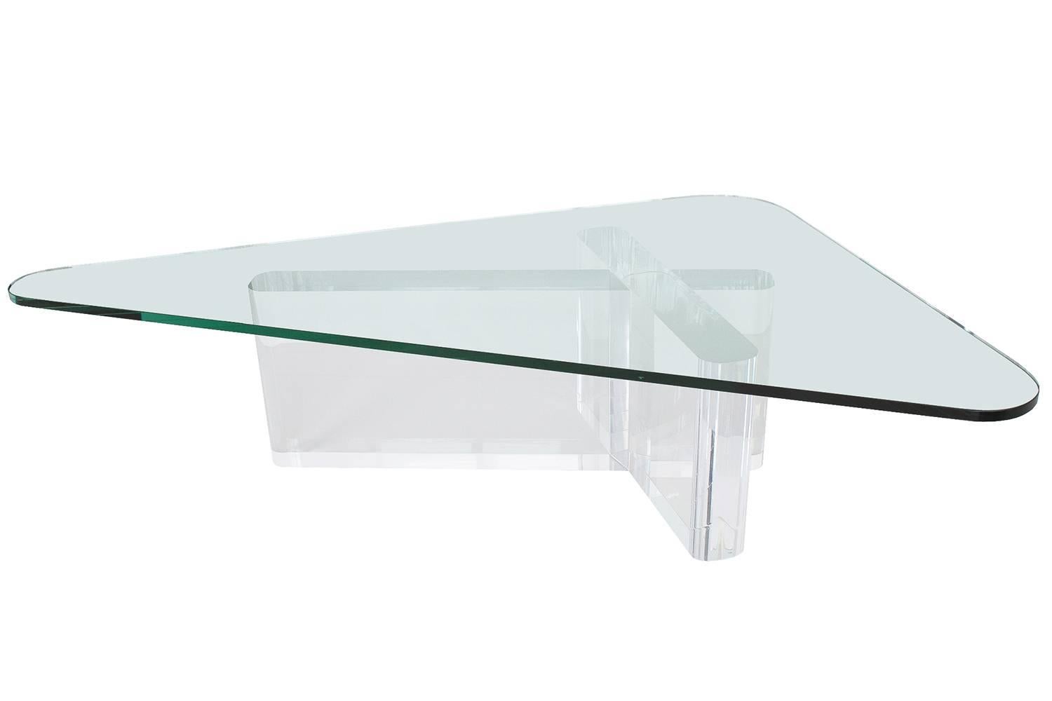 Cross shaped thick Lucite coffee table with triangular glass top by Lion in Frost. 4" thick clear Lucite with rounded ends. Three separate pieces of Lucite are positioned to create the sculptural base. 3/4" thick triangular glass top