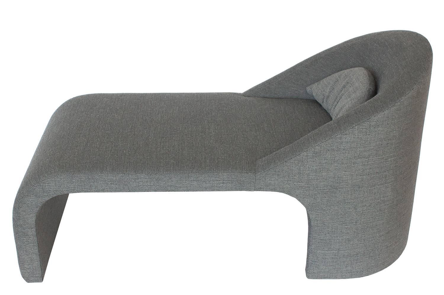 A modern sculptural fully upholstered chaise longue in the style of Vladimir Kagan. Waterfall front and barrel back with a loose half moon pillow. Newly upholstered in a steel grey woven chenille fabric. Fabric swatch available upon request.