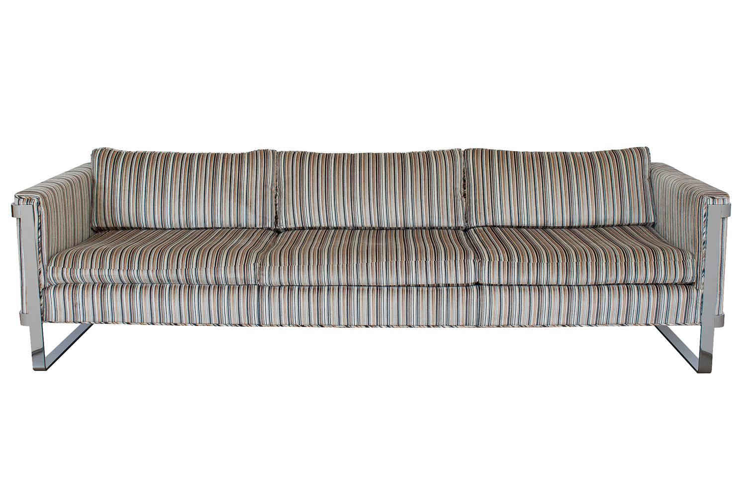 Milo Baughman chrome flat bar sofa in the original striped velvet upholstery. Upholstered three-seat sofa is cradled and floats within chrome-plated steel legs and exposed sides. 1.75" chrome-plated steel. Loose cushion seats and backs.