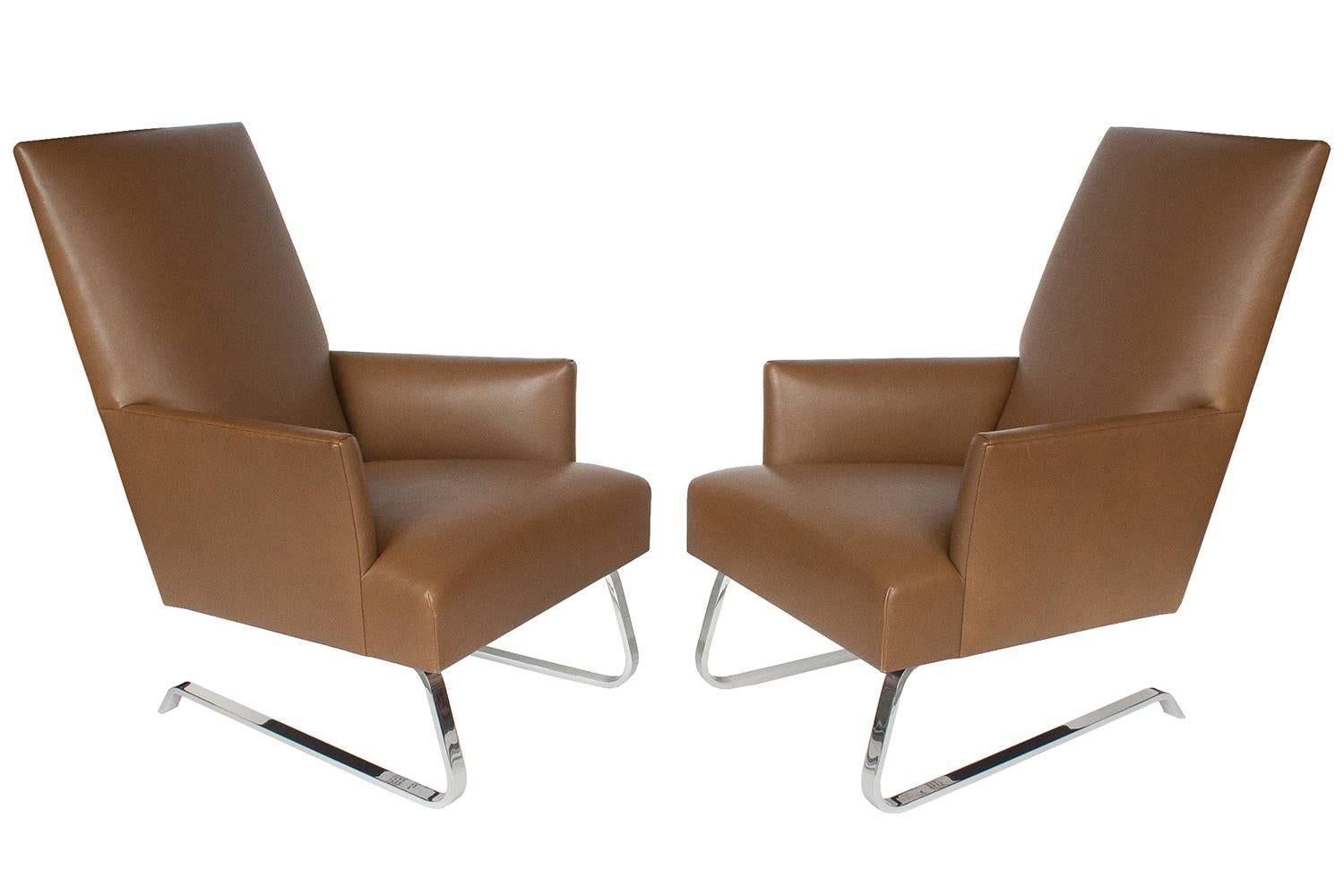 Pair of leather Odeon club lounge chairs by Donghia. Fully upholstered chair with tight seat and back. The upholstered frame is raised on a formed and polished chromed steel cantilever base. Upholstered in a light caramel brown leather. Leather