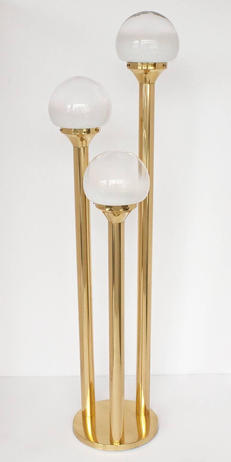Polished brass floor lamp with three tubular supports, each holding a Murano glass globe that is solid white at base graduating to clear at the top. Each globe is approximately 8" diameter. Stepped globes measure 57" H, 49" H x