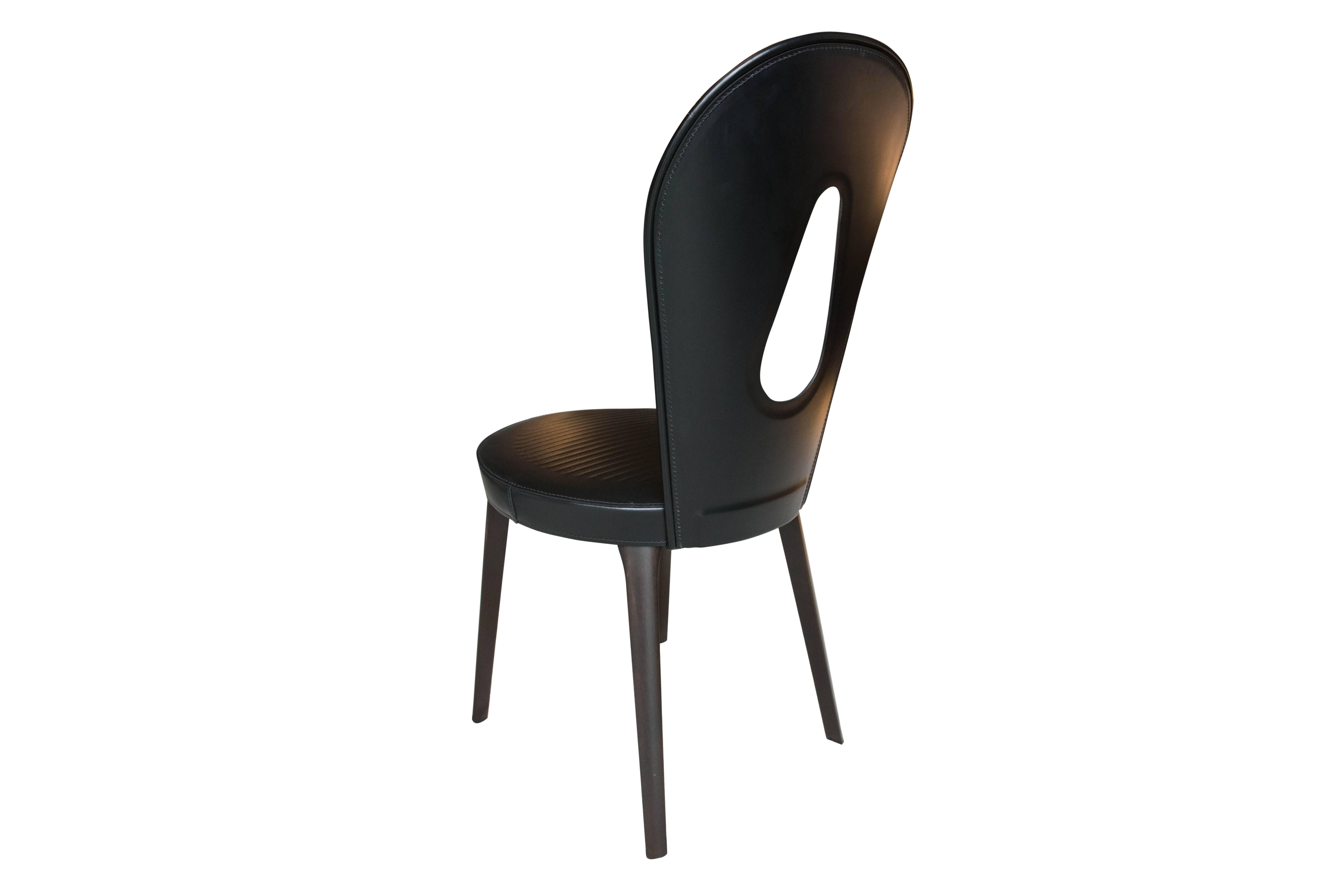 A dining chair with the legs in solid polished beech wood and the seat in multilayer beech wood. The padding is in multi-density polyurethane foam. The backrest structure is in curved aluminium. The saddle leather covering is available in various
