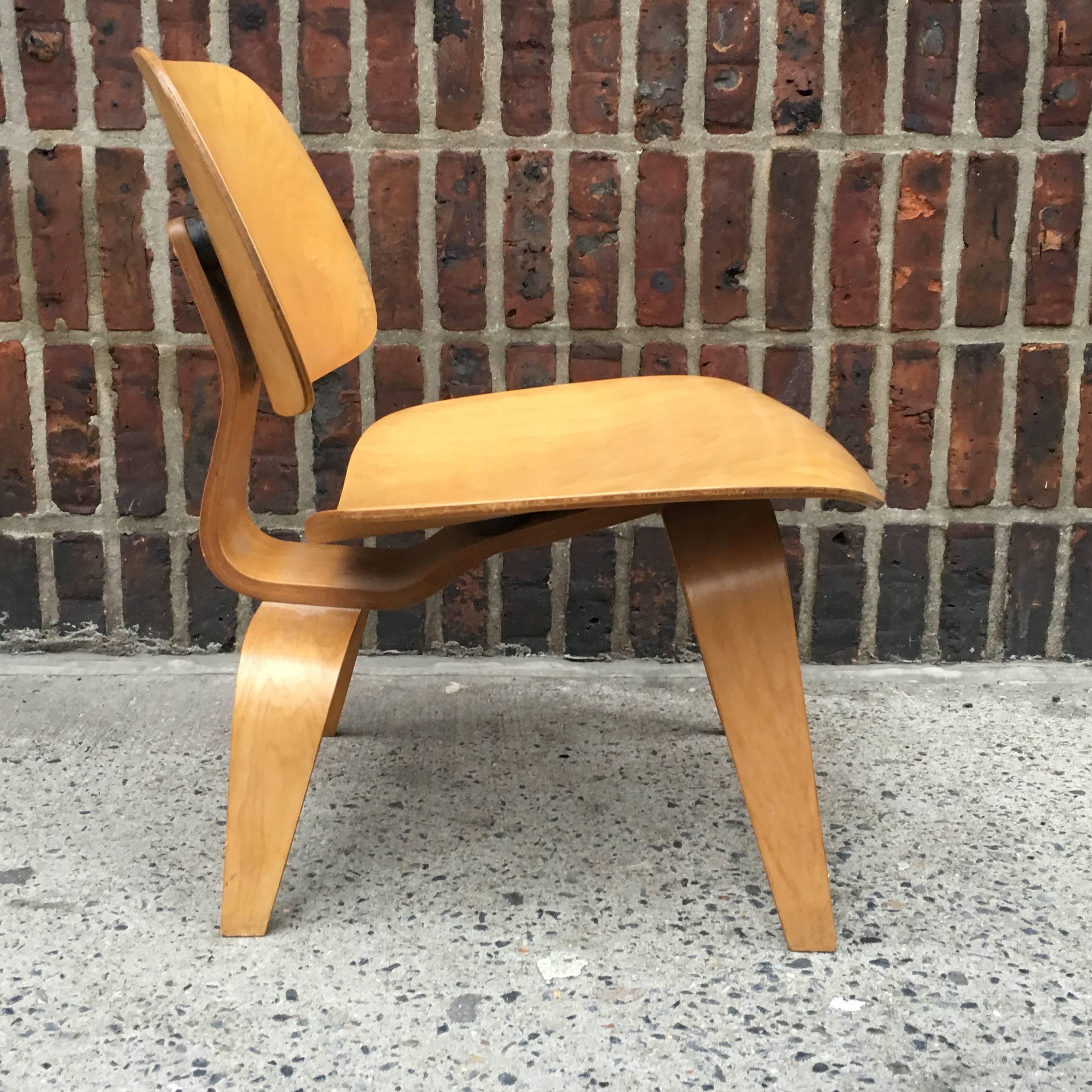 First edition Eames LCW with earliest Evans label intact. Lovely figured birch grains with excellent patina. Unrestored and completely original down to the shock mounts and screws, which have never been unscrewed. No veneer chips are commonly found