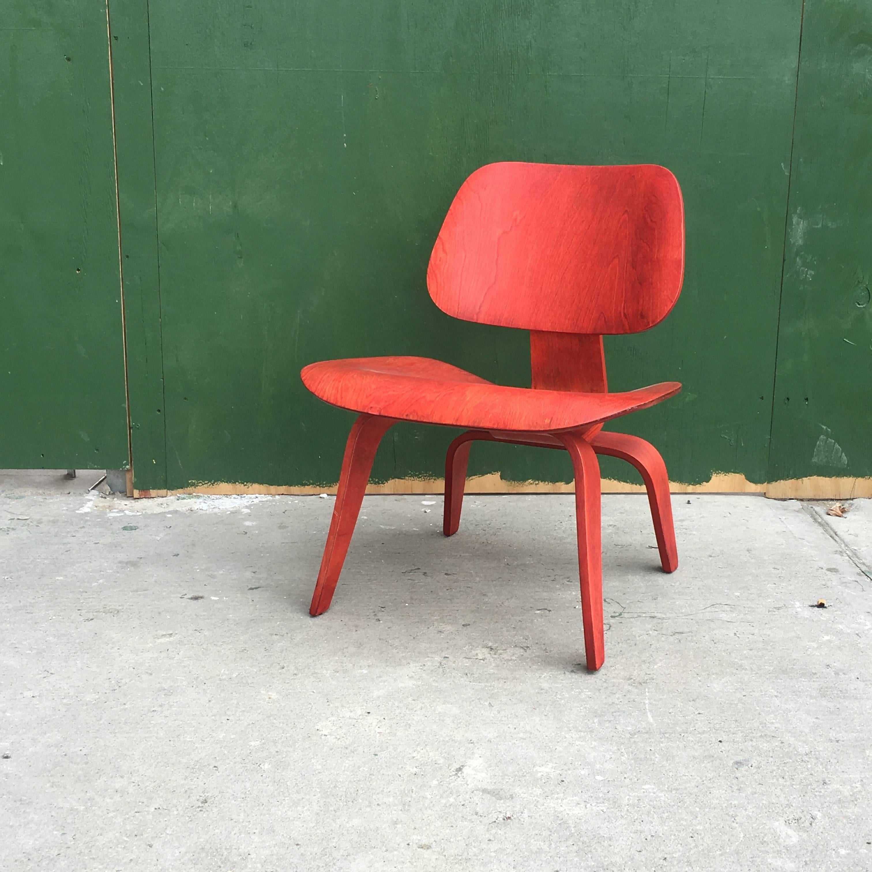 Early Eames LCW manufactured by Evans Products in the 1940s. Rare red version of the iconic chair. Chair is structurally sound and in great shape given age. Shock mounts reglued at some point. Bright vibrant red aniline dye on birch veneers.