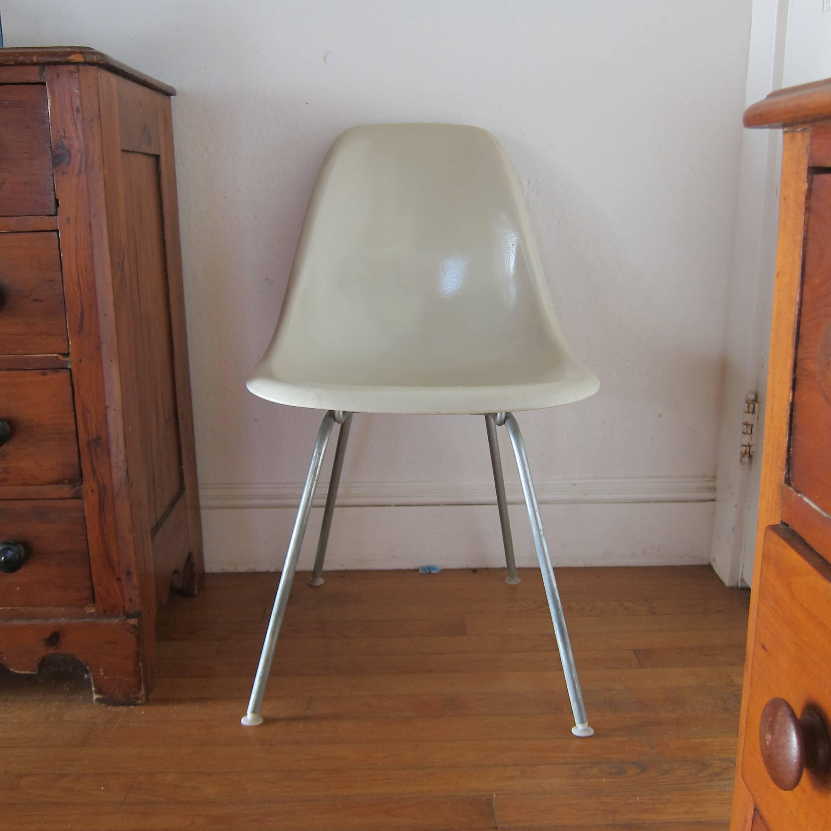 Four Herman Miller Eames fiberglass dining chairs. Colors include parchment navy blue, seafoam green, and elephant grey. The latter three are particularly hard to find. No cracks or damage besides normal vintage wear. Bases are original Herman