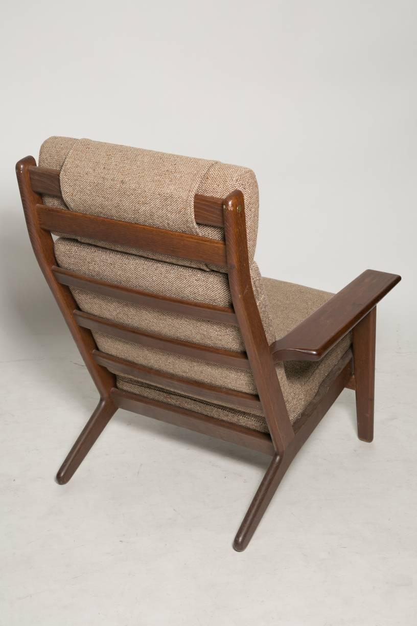 Great vintage high back lounge chair designed in 1953 by designer Hans J. Wegner for GETAMA. Smoked oak and brown wool fabric. Iconic chair of the Mid-Century Modern.
 